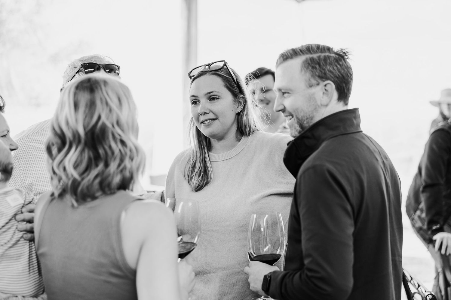 A series of black and white photographs showing candid moments between people at what appears to be a wedding celebration.