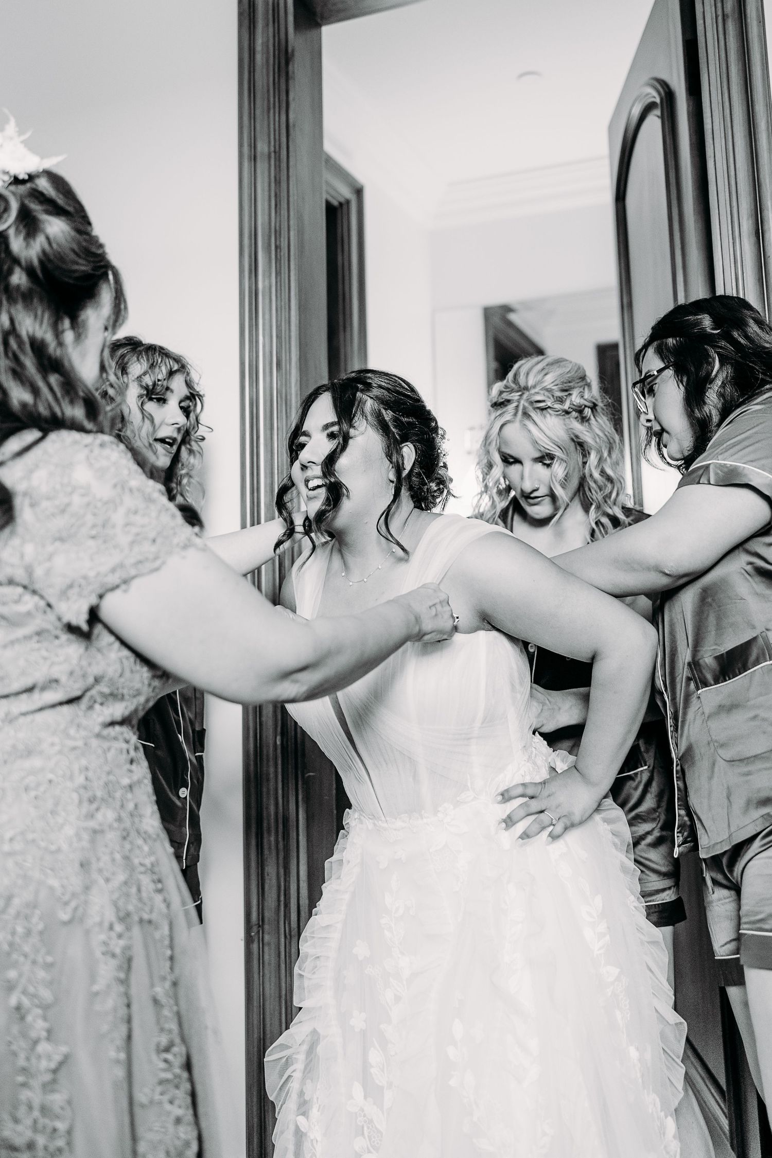 A candid black and white photo of getting ready in formal attire with delicate details and emotions.