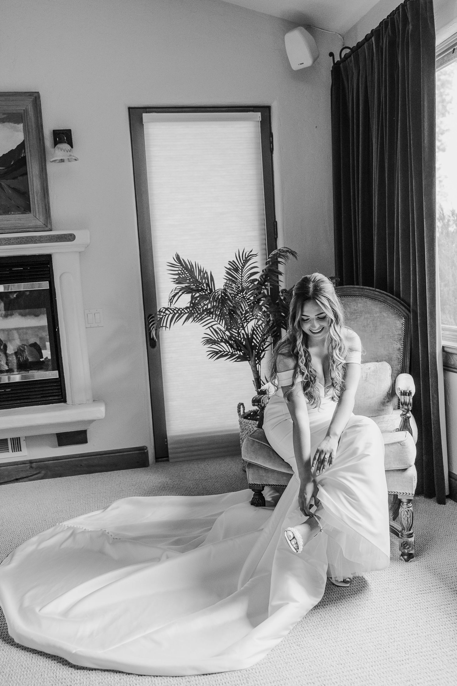 Black and white sequence of a bride sitting and posing in an elegant white wedding gown on a light carpet.
