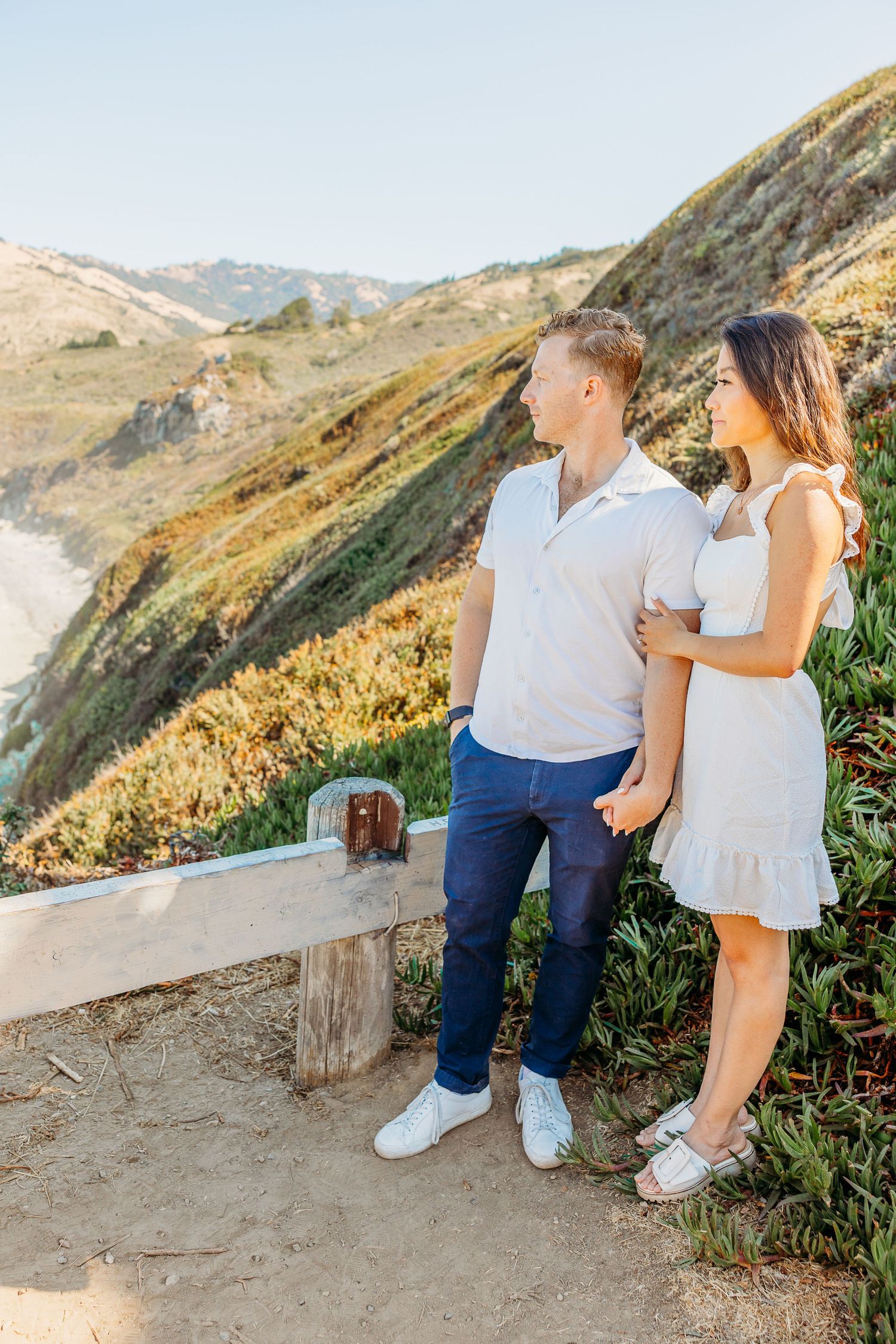 A couple enjoys the scenic coastal mountain views together on a hiking trail.