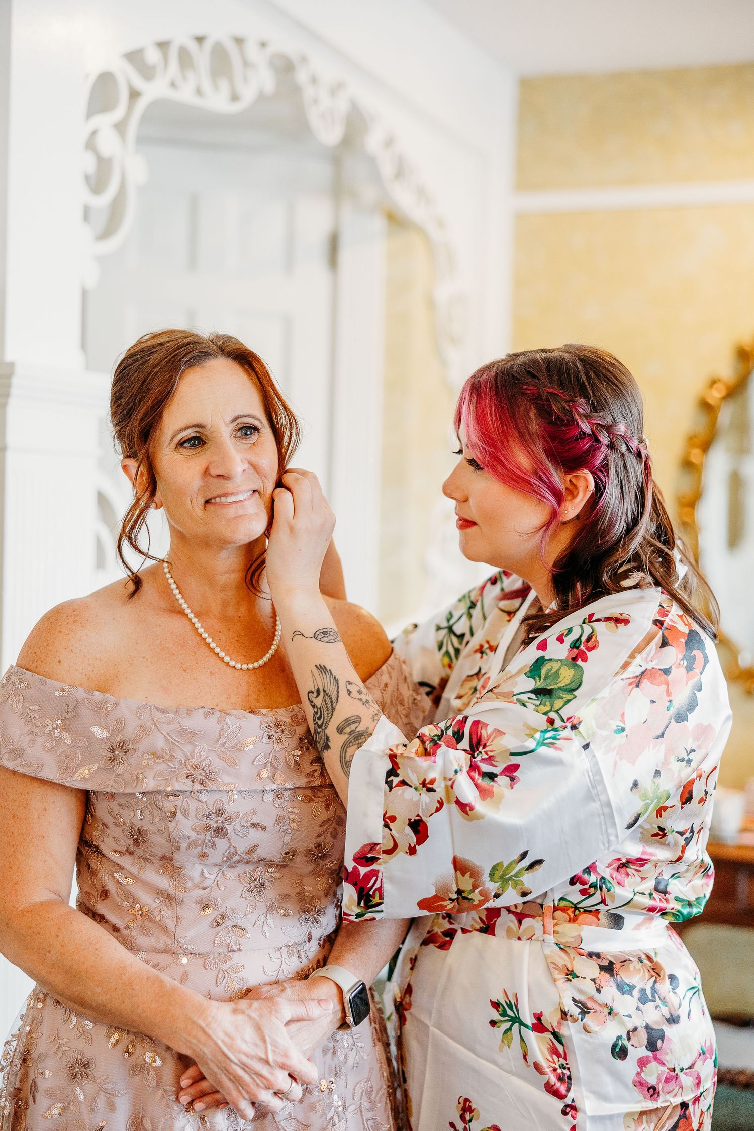 Getting ready for a wedding with someone wearing a blush gown and another in a floral robe.