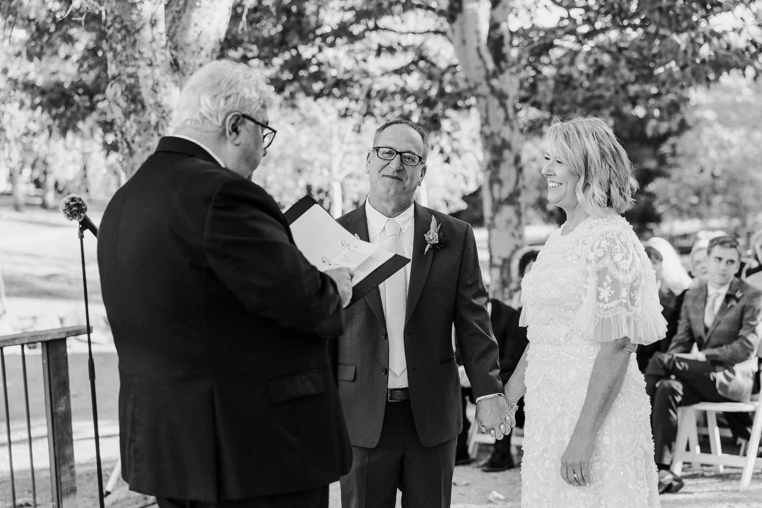 Wedding party gathered outdoors in formal black and white attire during a celebration.