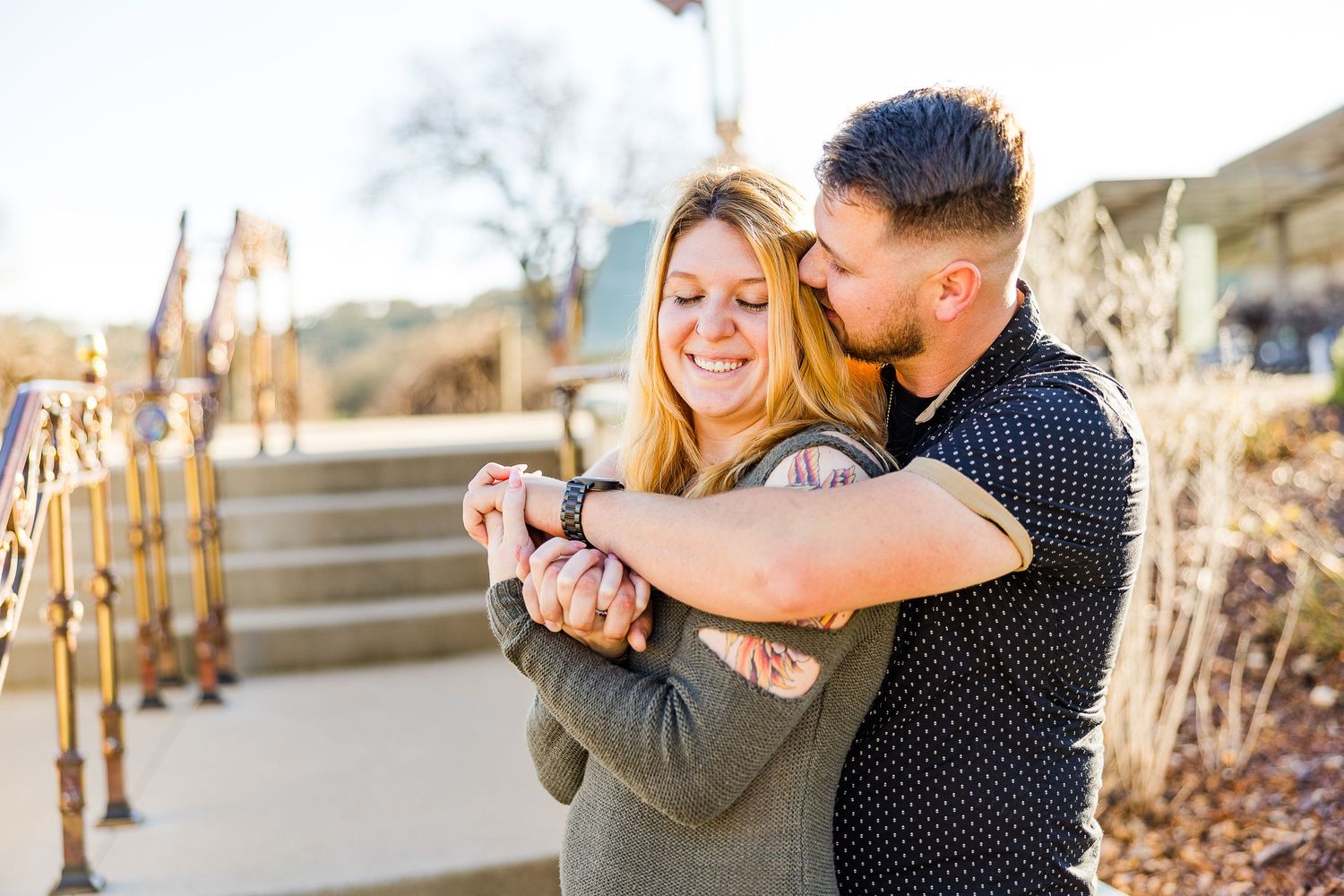 Joyful embrace captured in warm sunlight on outdoor steps.