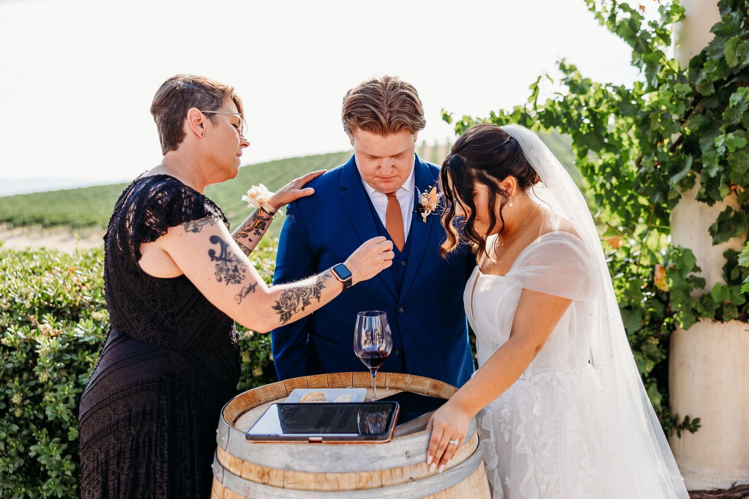 Wedding party performs wine barrel ceremony during outdoor vineyard celebration.