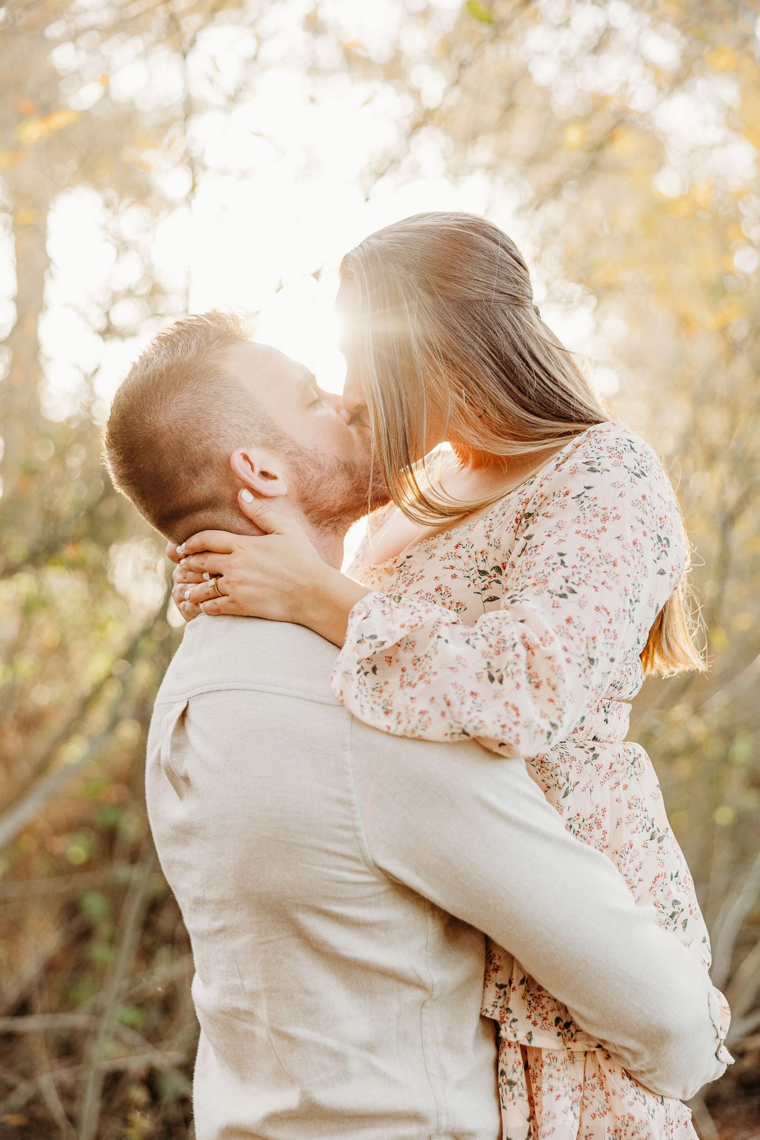 Romantic couple sharing tender moment in golden sunset lighting.