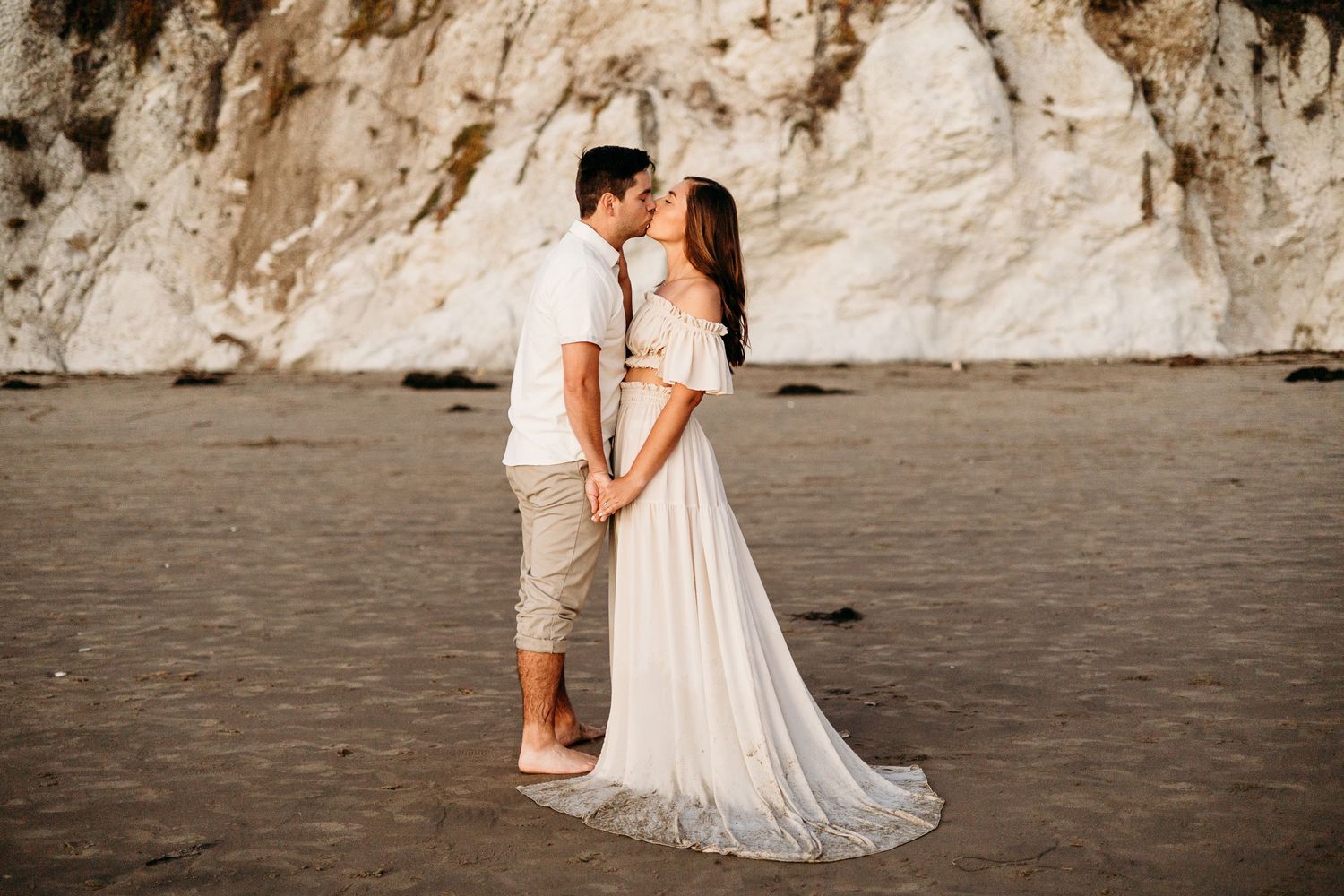 A romantic beach wedding photoshoot with white cliffs in the background.