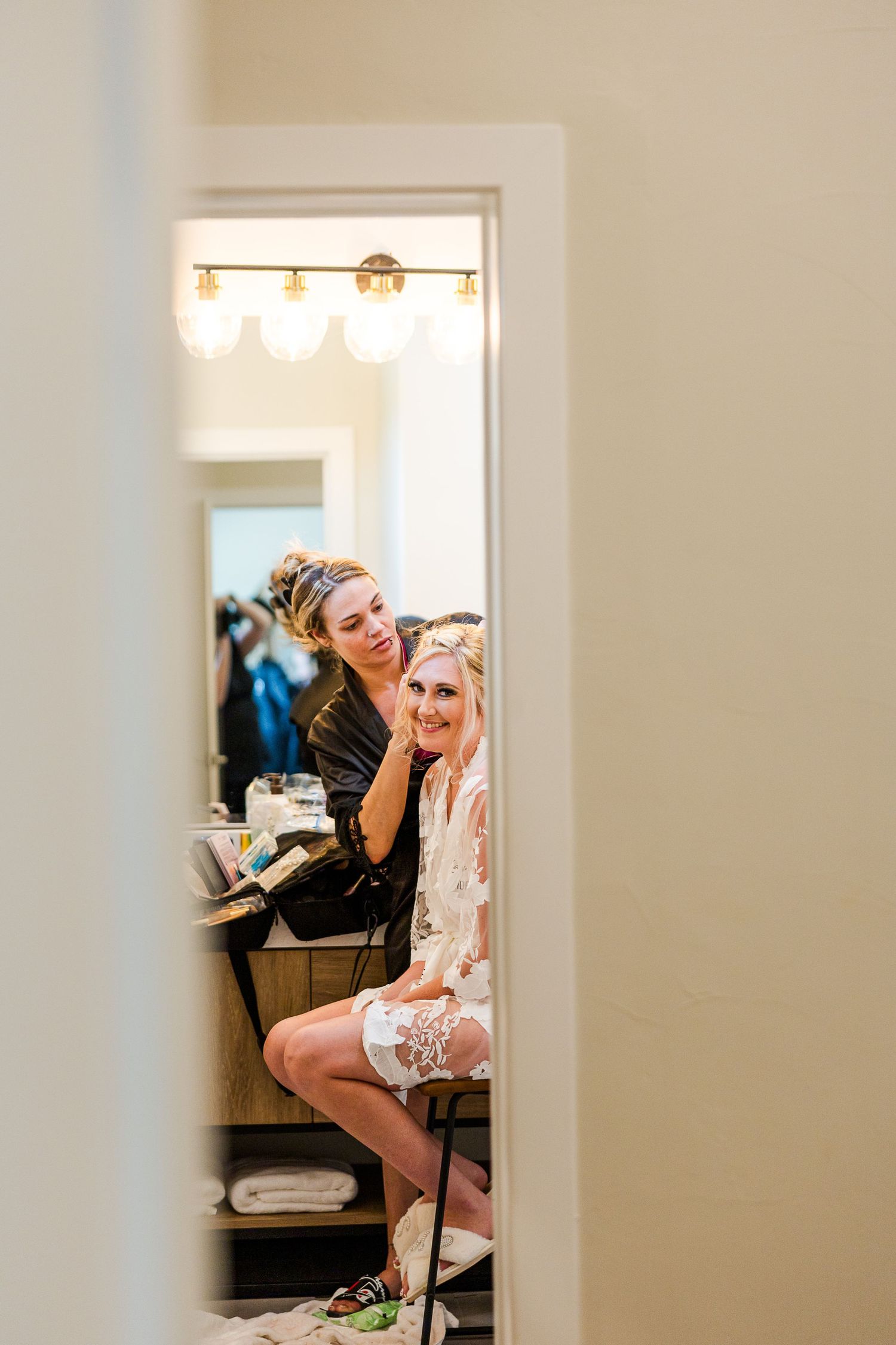 Mirror reflection shows wedding preparation moments in bridal suite.