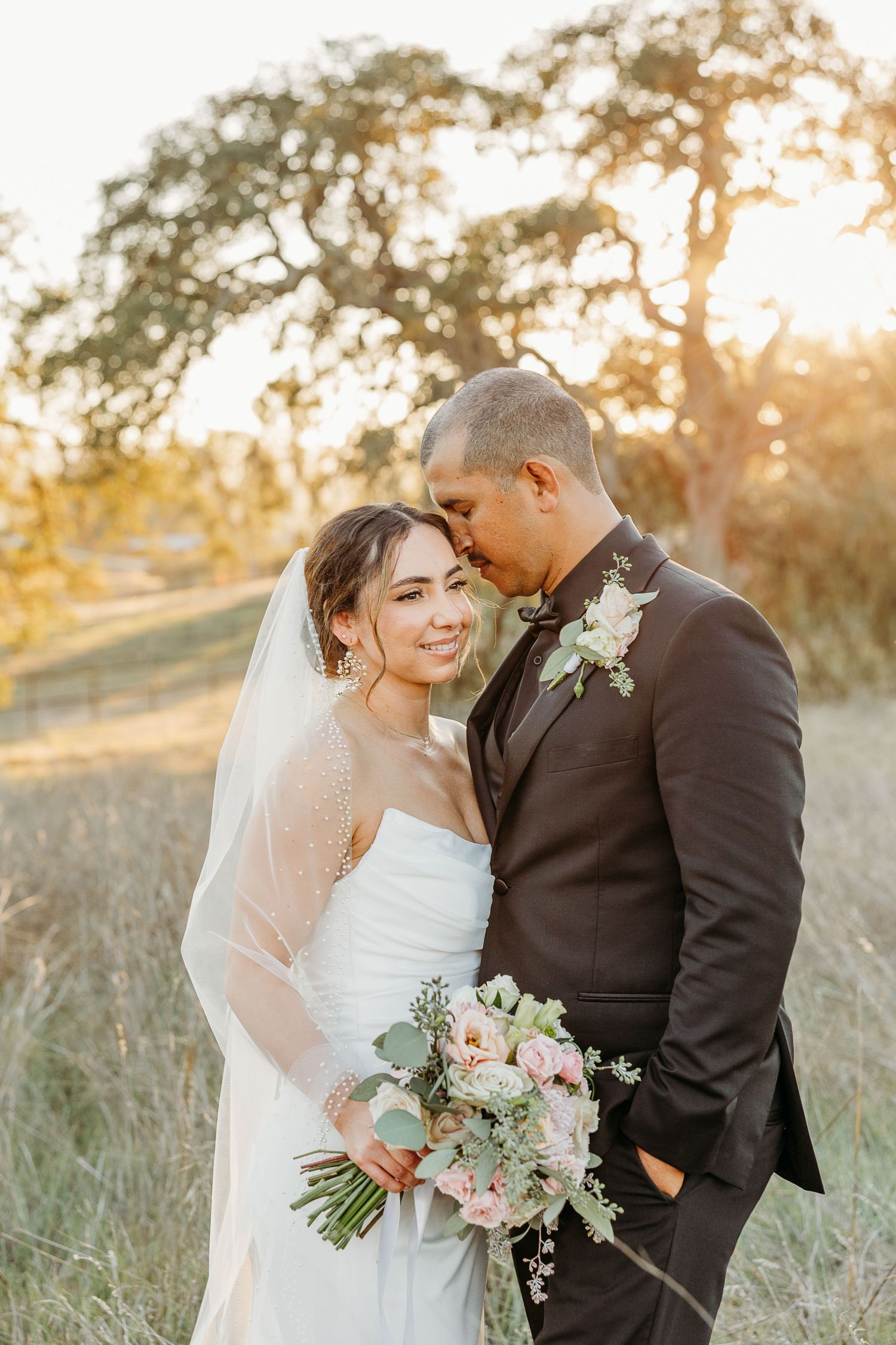 Intimate wedding portraits captured during sunset showing tender moments between newlyweds with a floral bouquet.