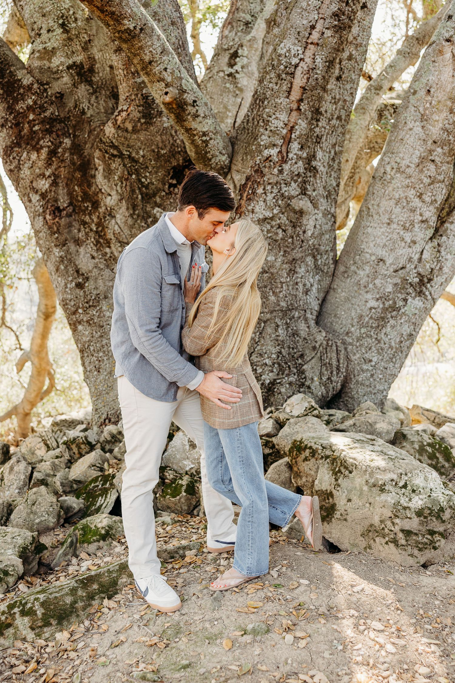 Series of romantic moments captured by an ancient tree in natural lighting.