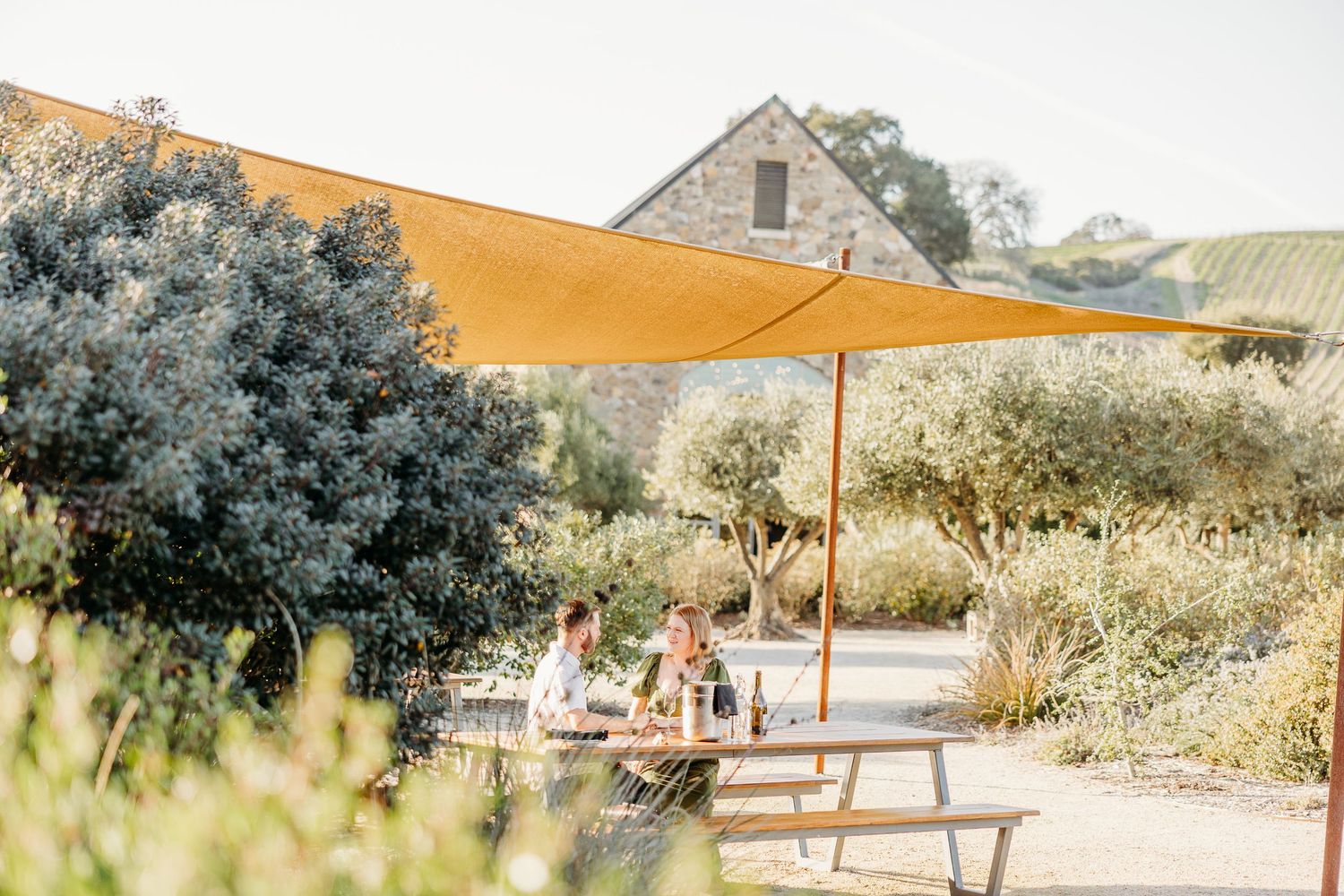 A romantic outdoor scene with yellow canopies and stone buildings in the background on a sunny day.