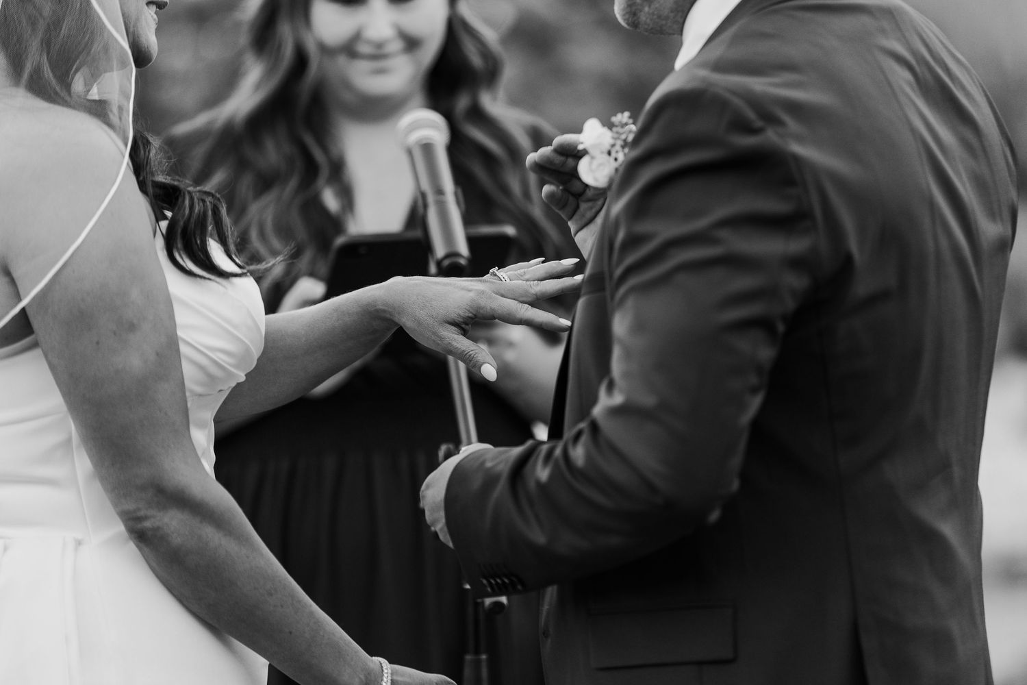 Candid black and white wedding moments show joyful interactions during outdoor celebration.