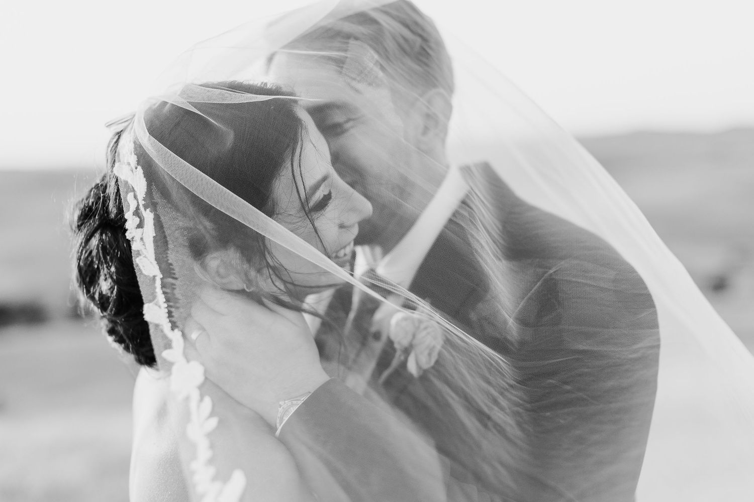 Ethereal wedding veil floating in the breeze during an outdoor photoshoot.