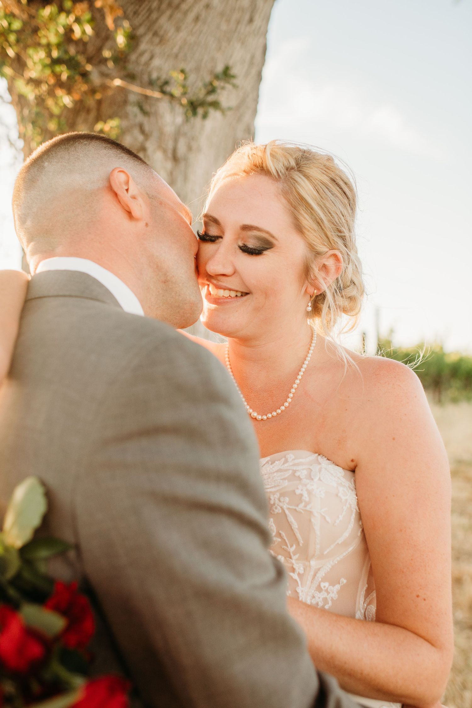 A romantic close-up moment between newlyweds in warm sunset light.