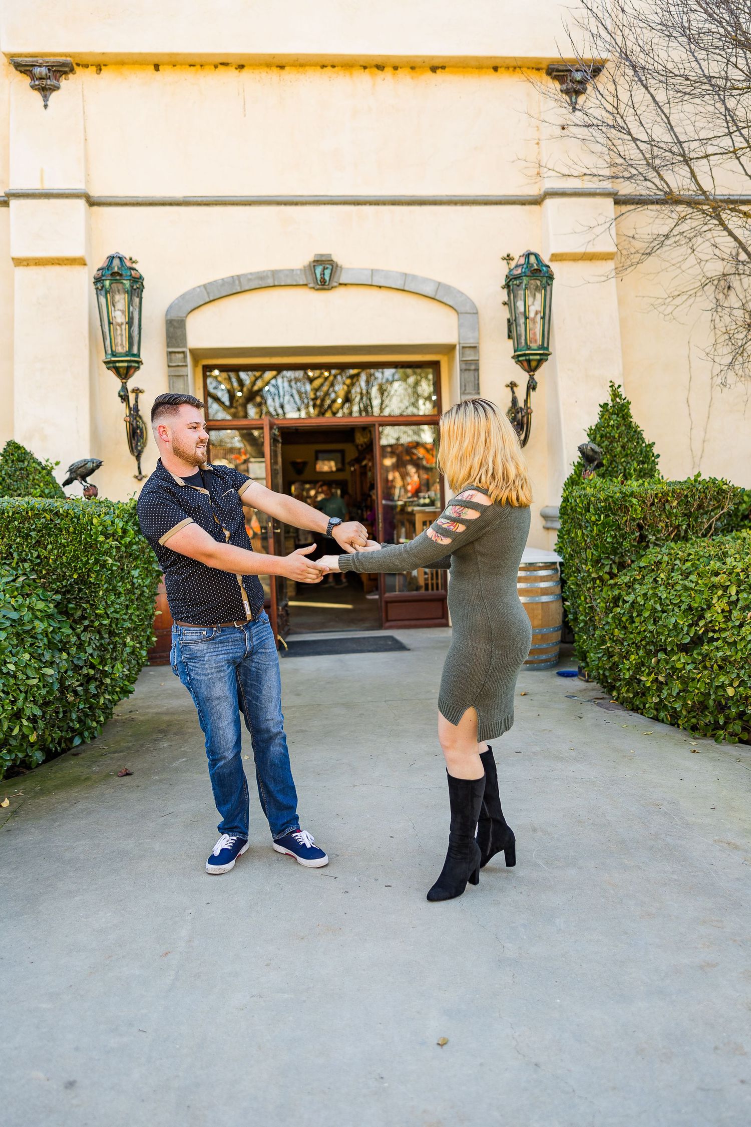 Dancing couple spins together on outdoor patio with decorative lanterns and wine barrel decor.