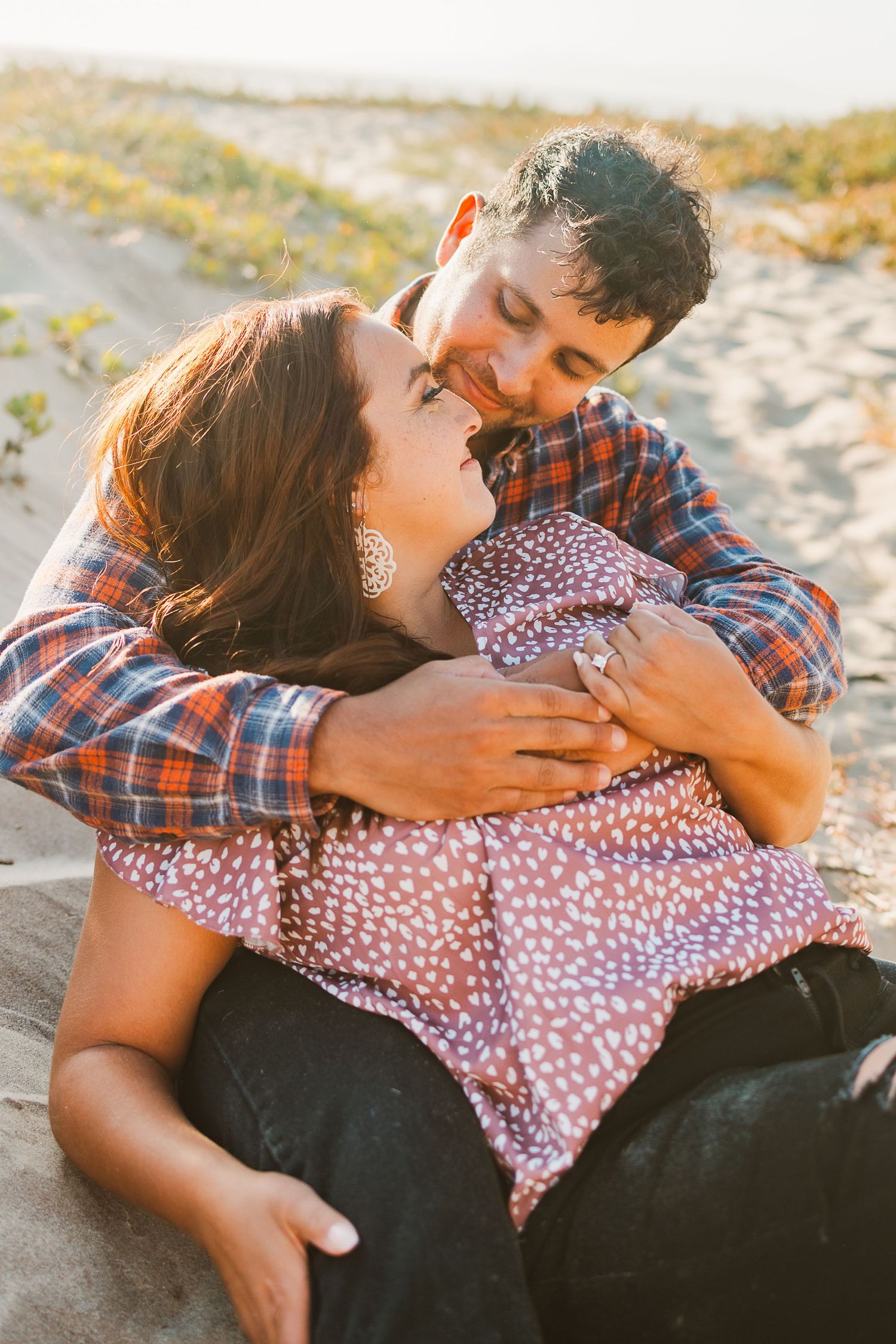 Intimate moment between couple during beach sunset photoshoot.