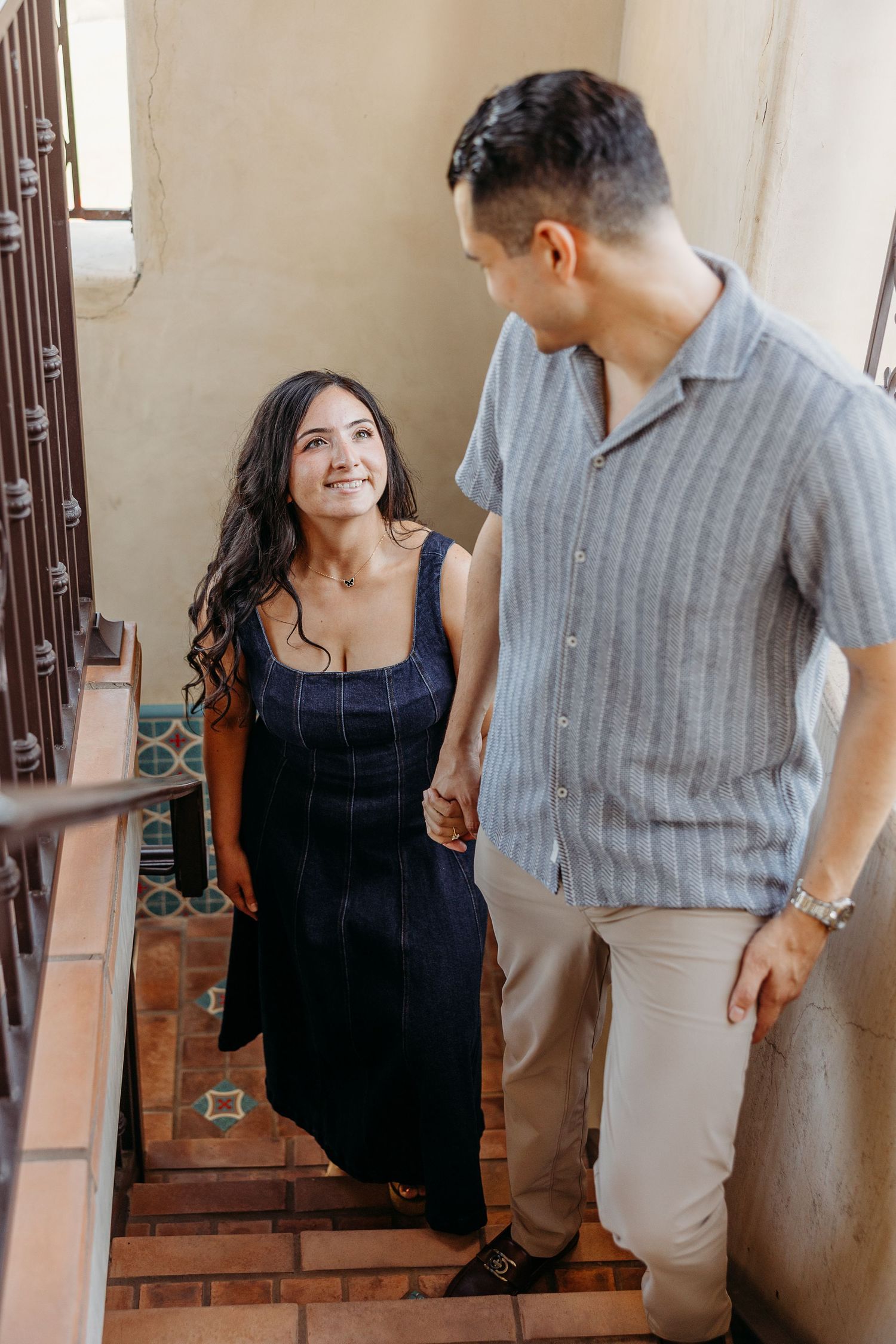 A couple sharing a joyful moment together on a rustic staircase.