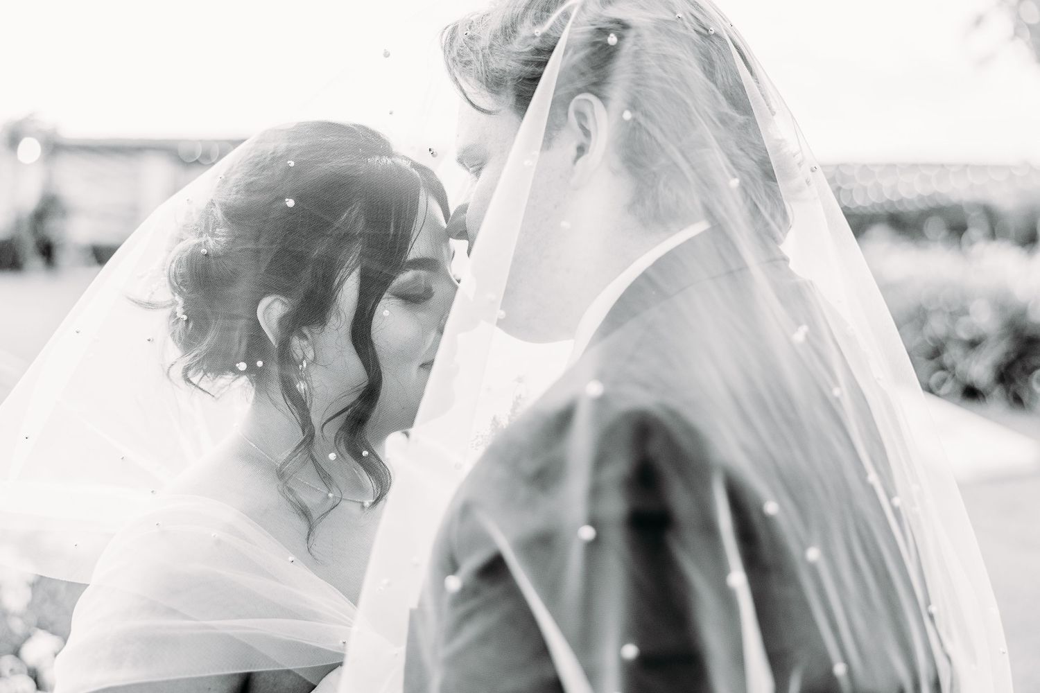 Black and white romantic portrait of newlyweds sharing intimate moment.