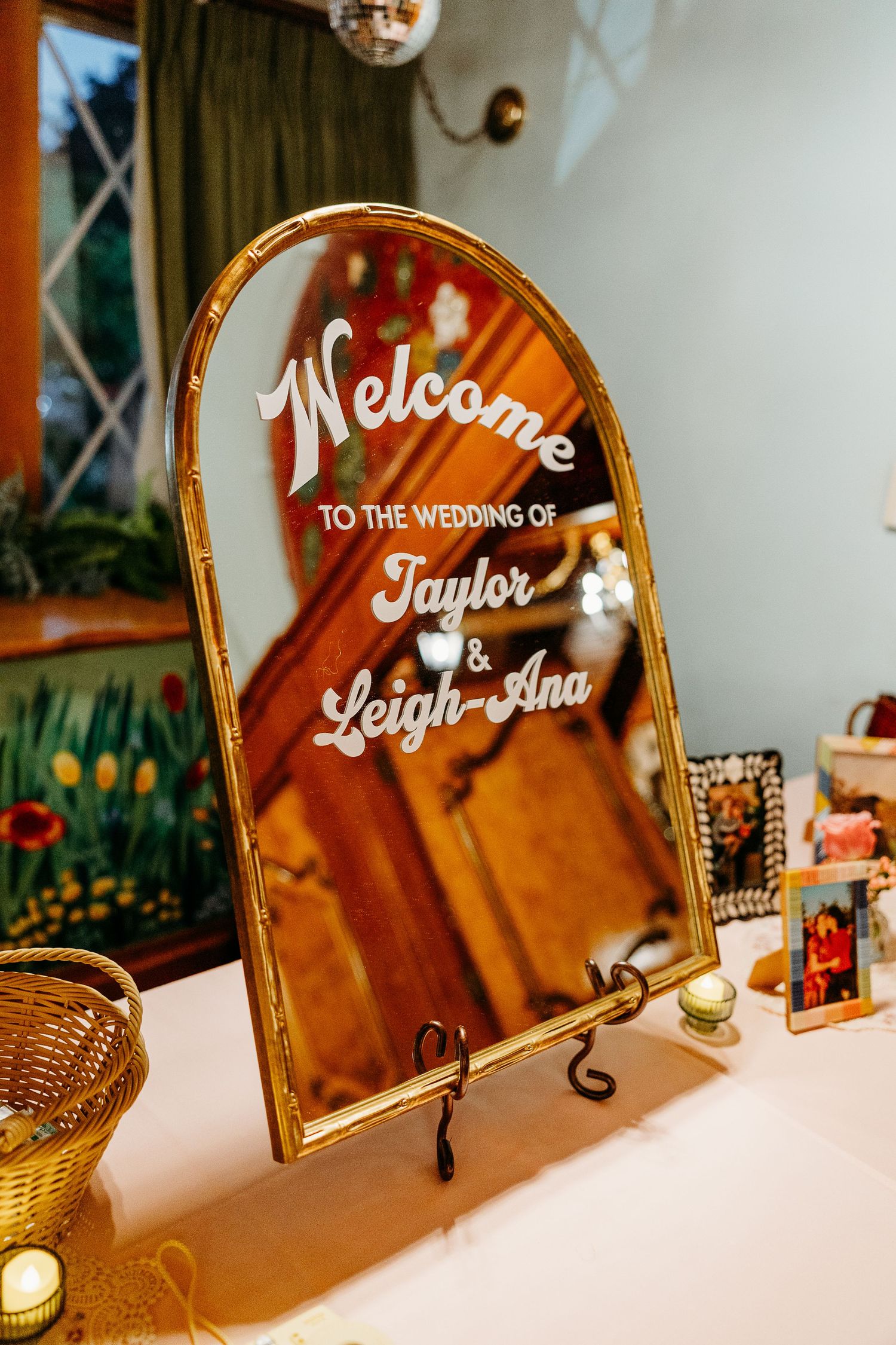 An elegant gold-framed mirror displays a wedding welcome message with cursive lettering.