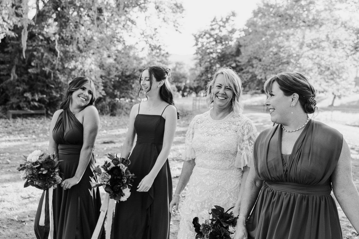 Wedding party in navy and burgundy attire walking together outdoors.