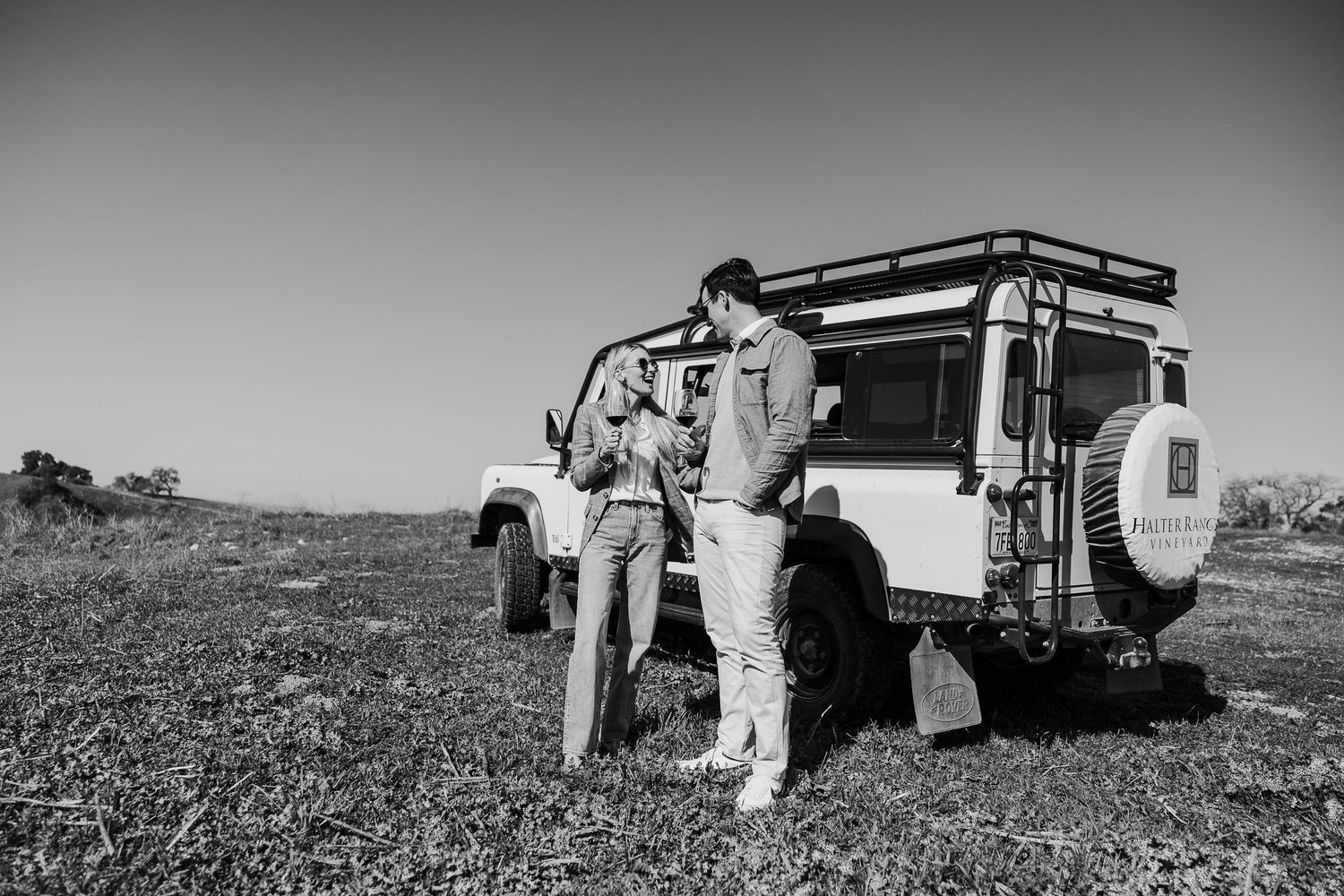Black and white series of couple by vintage truck in rustic landscape.