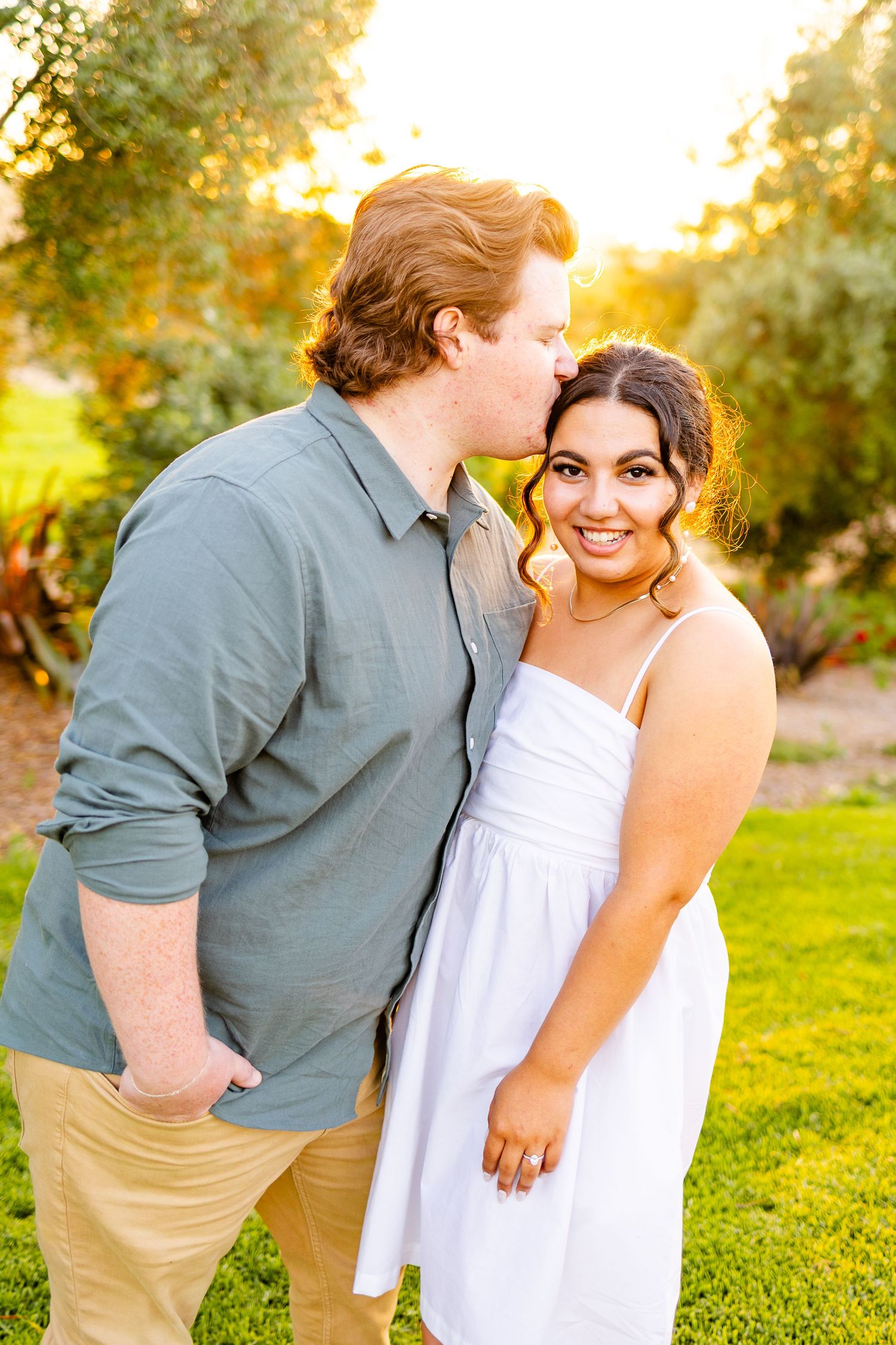 Sweet moment shared between couple in garden with golden sunset lighting.