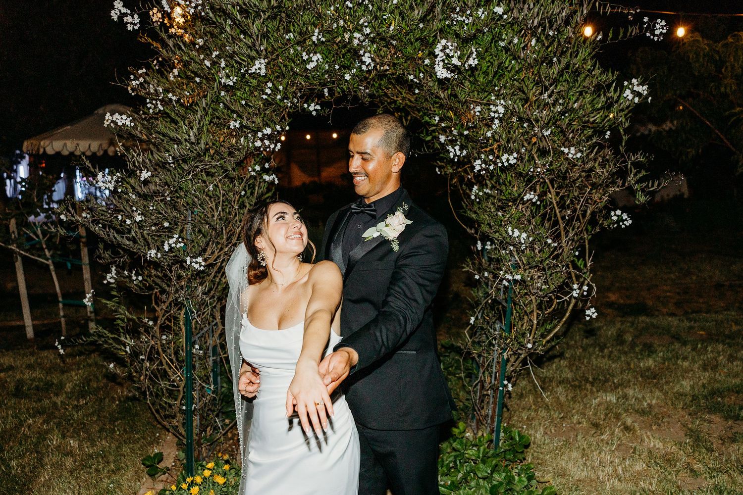 Couple sharing an intimate dance moment in a dimly lit outdoor setting.