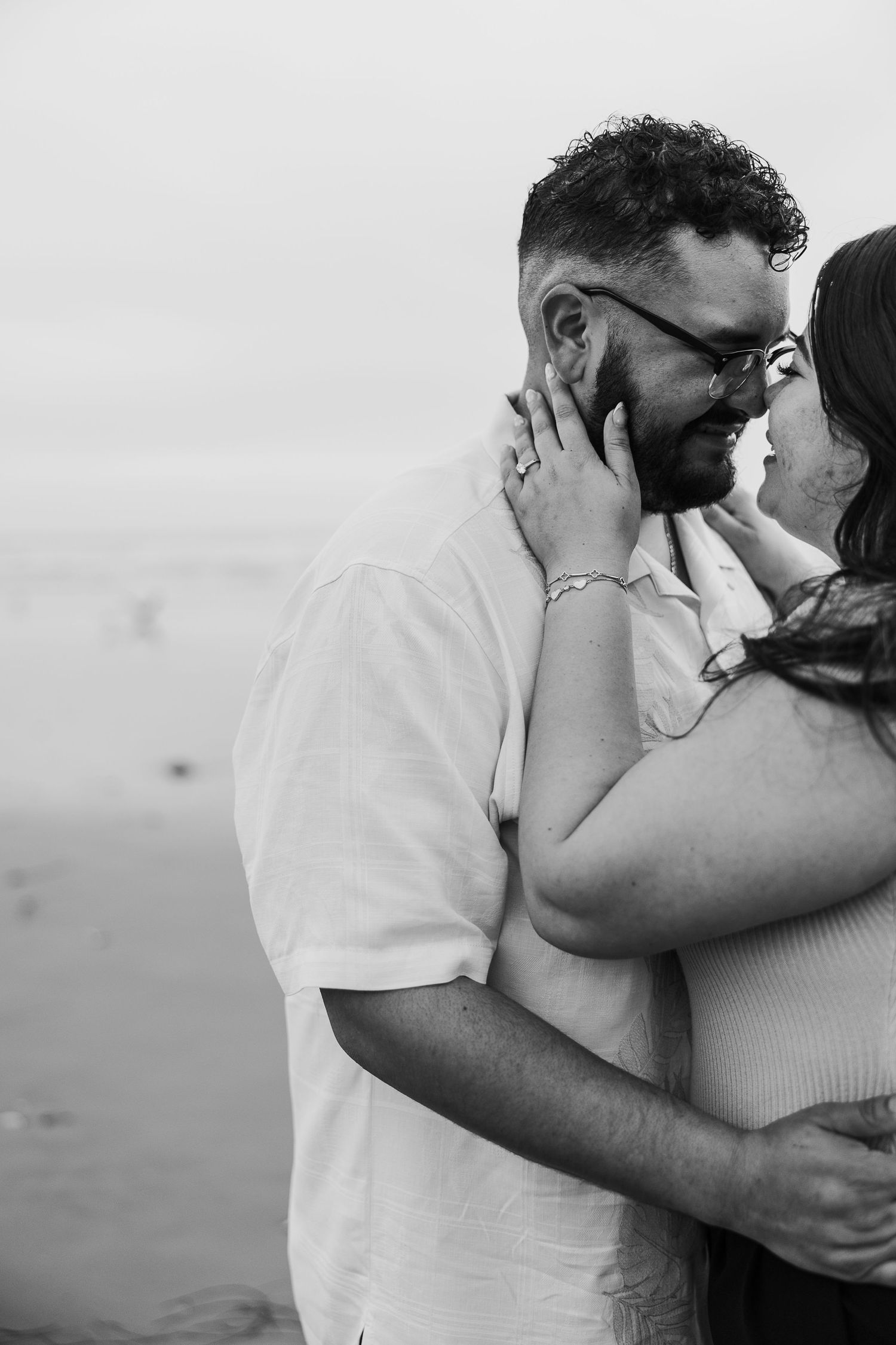 Intimate black and white photo sequence showing a couple embracing on a cloudy day.