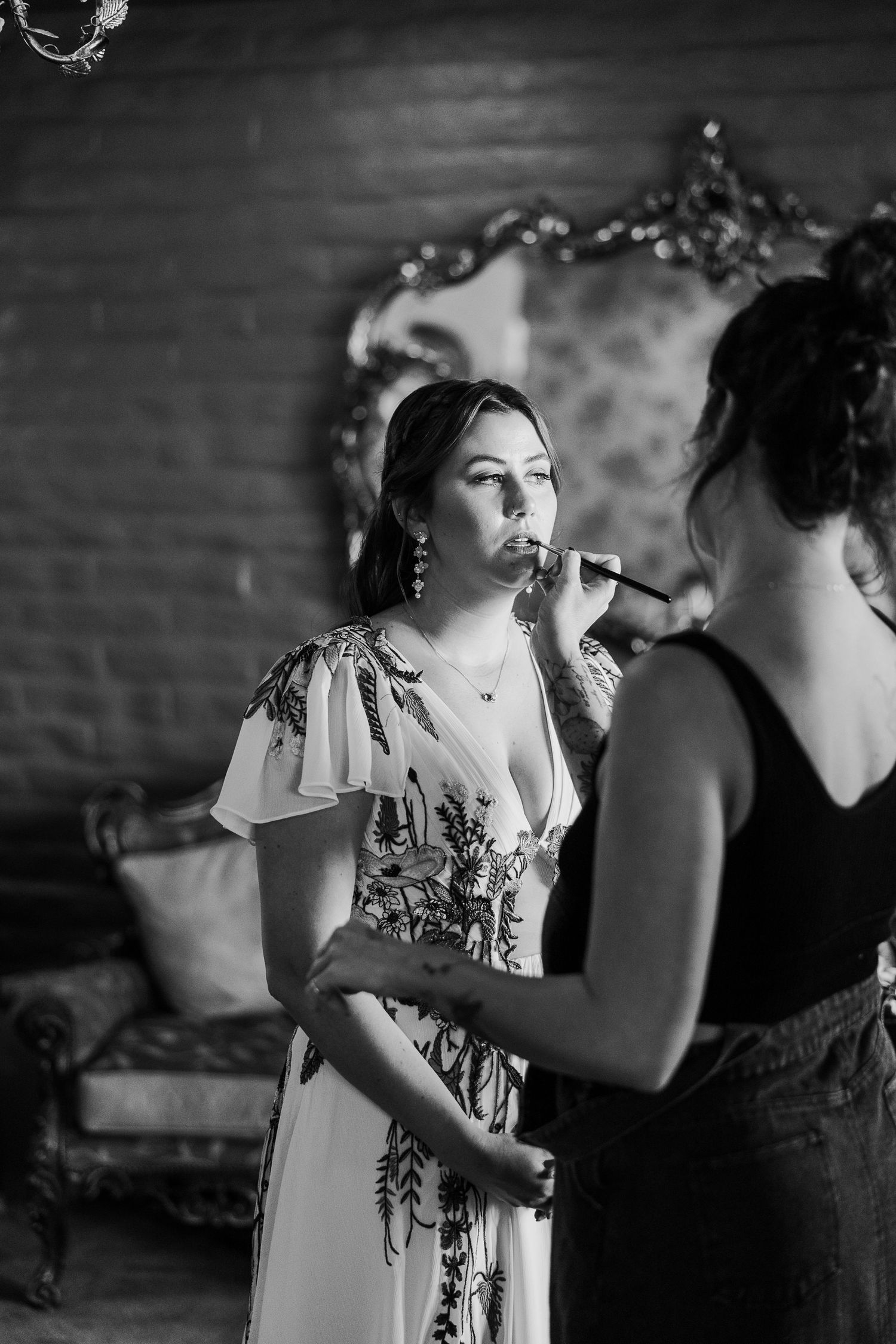 A black and white candid moment shows guests at a wedding reception in casual conversation.