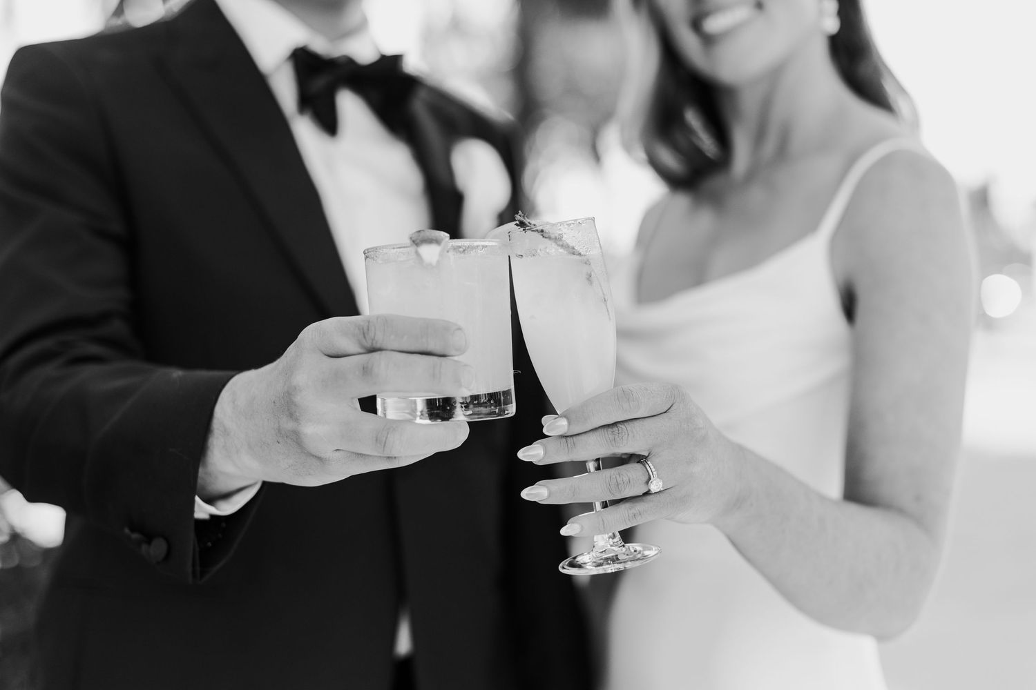 Close-up shot of champagne glasses being held during a wedding toast celebration.