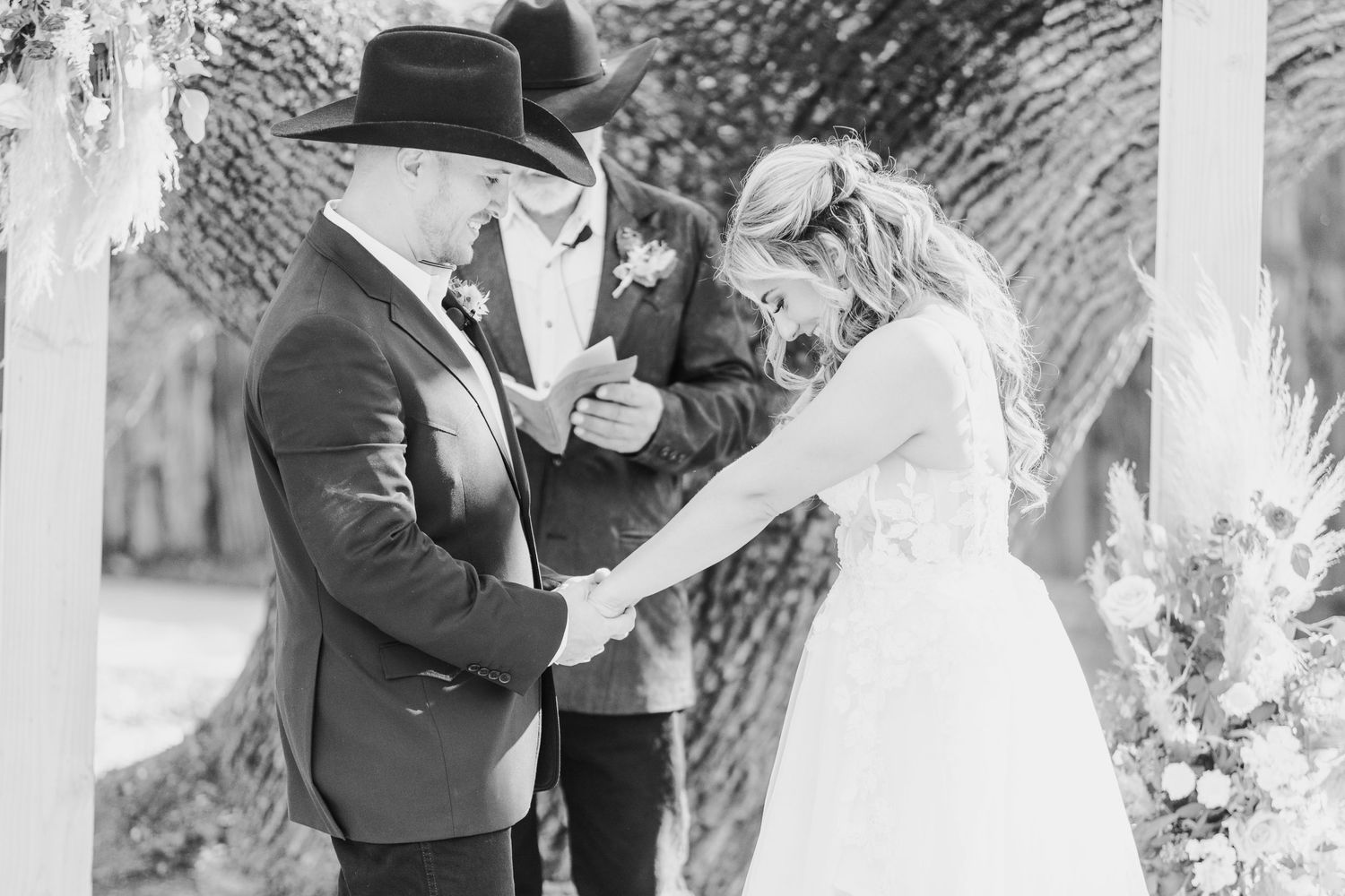 An intimate moment captured during a western-themed outdoor wedding ceremony.