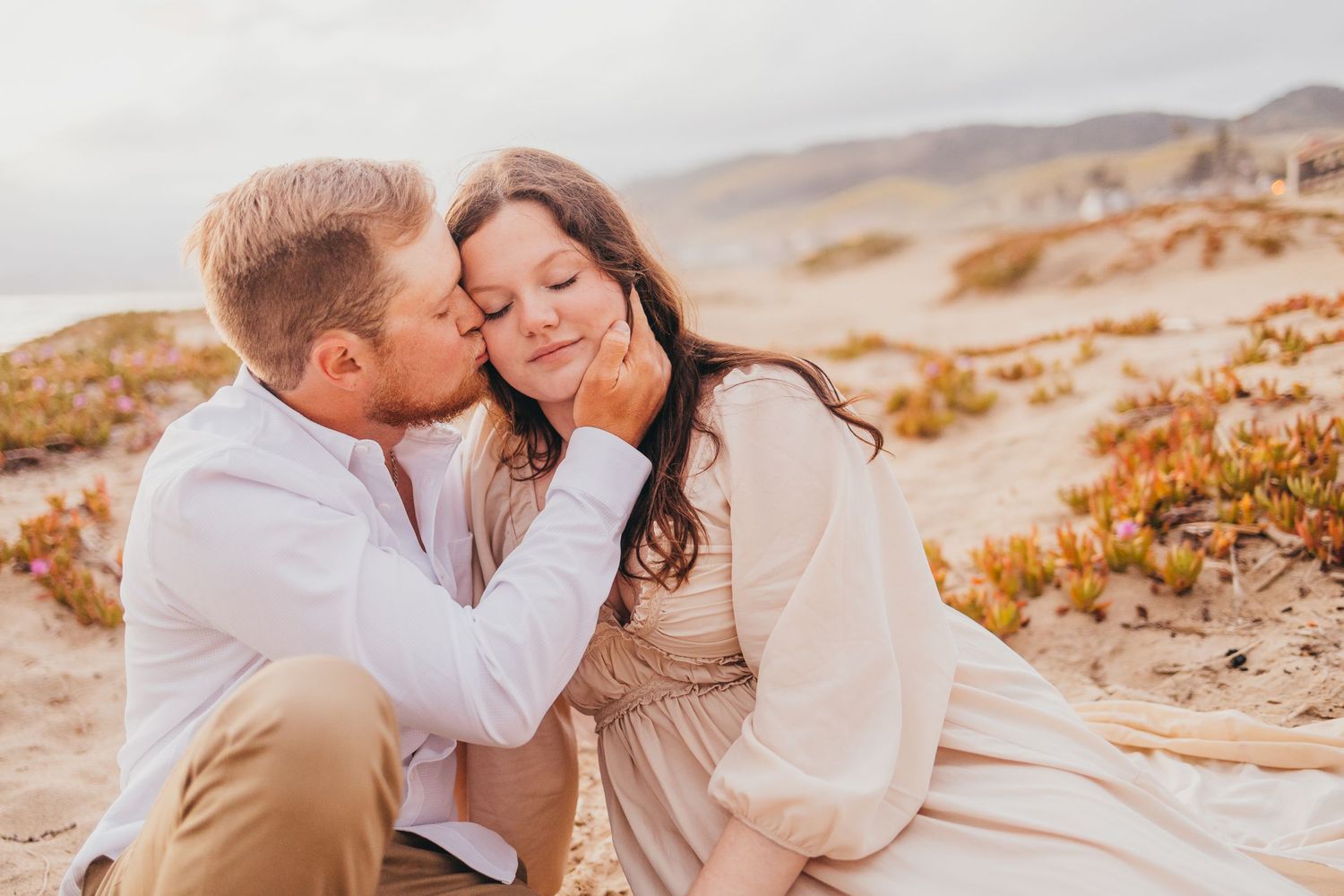 Sweet moment captured between couple during sunset beach photography session.