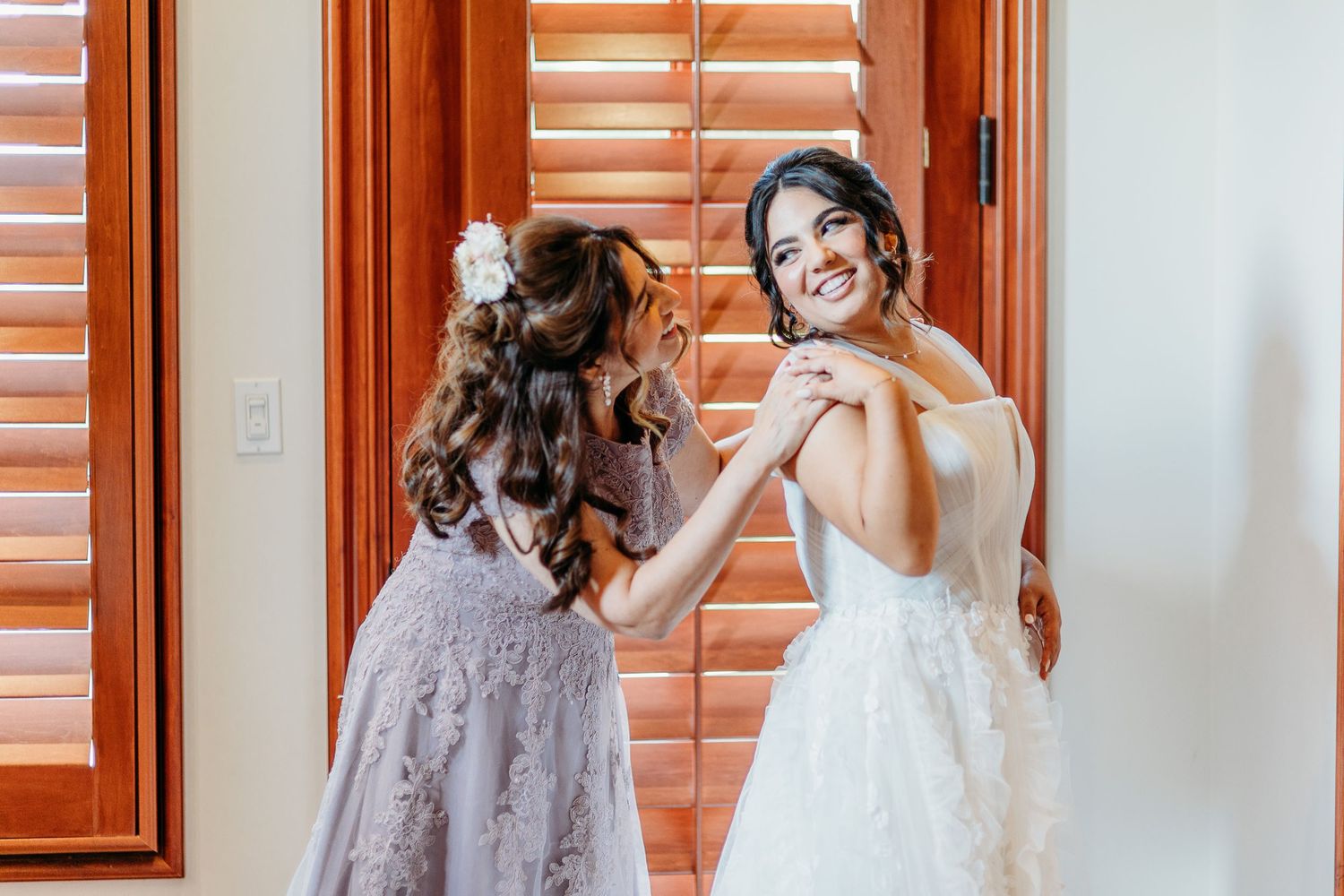 An intimate moment captured in soft lighting as final preparations are made for a special celebration.