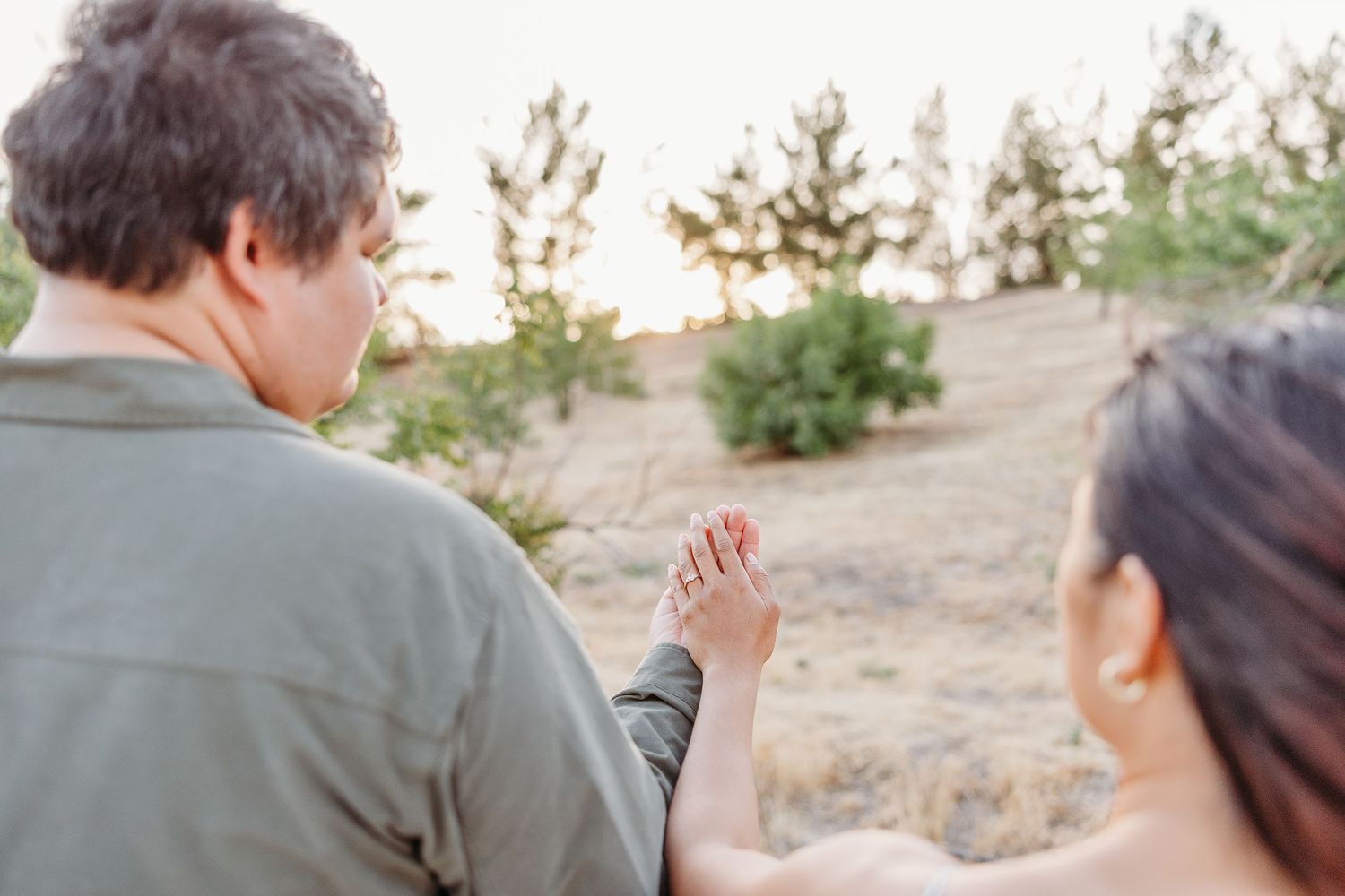 Two people wearing casual attire walk together at sunset in a desert landscape setting.