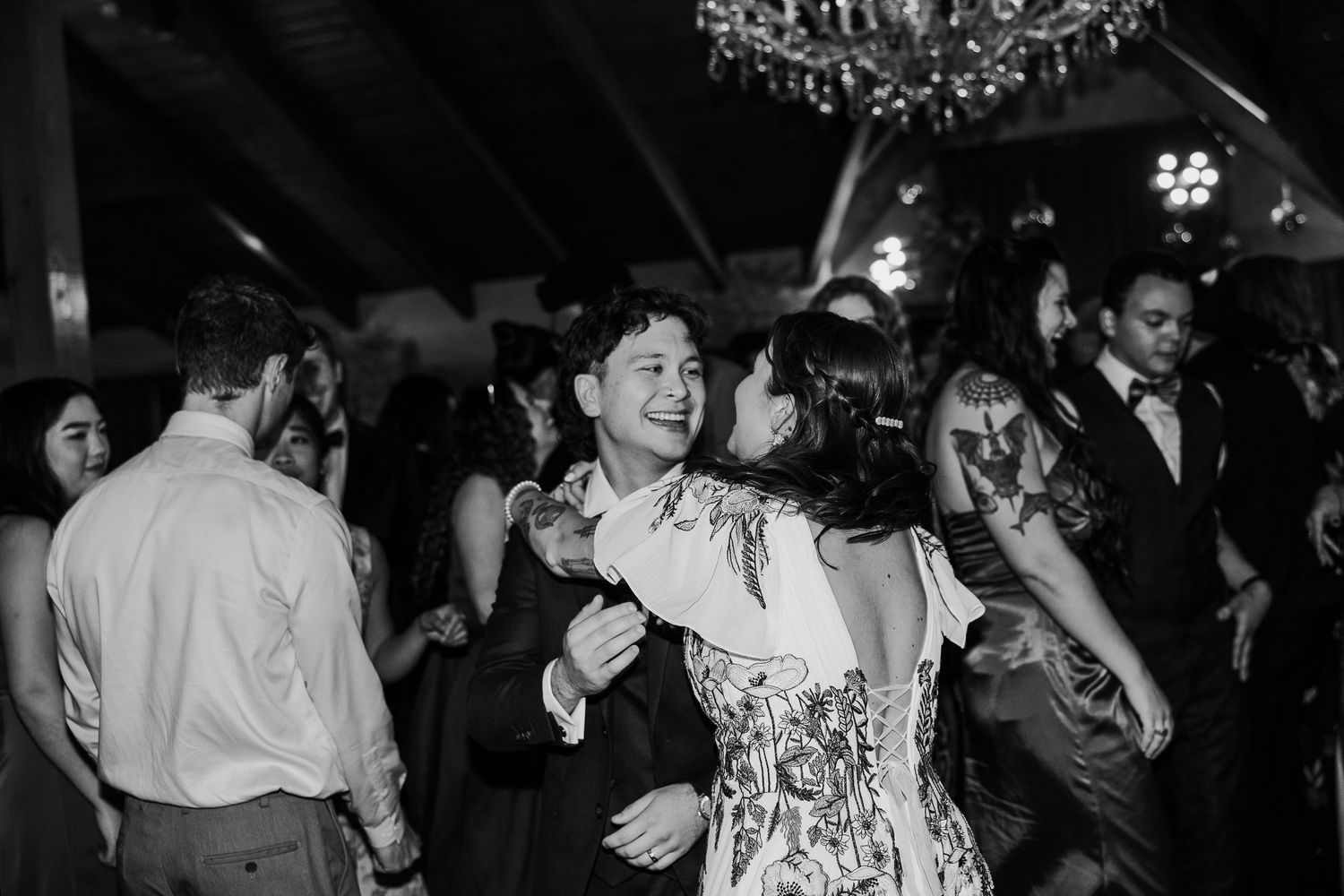 Dance floor moments captured in black and white during evening wedding reception.