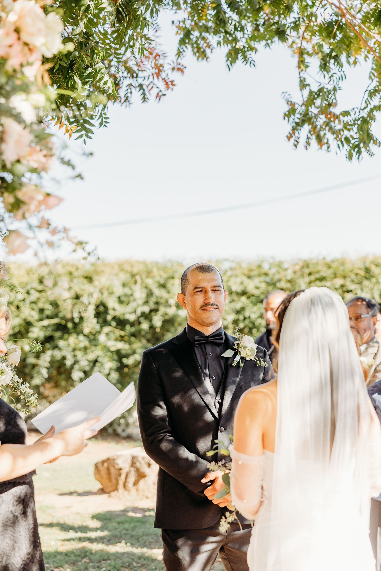 Wedding ceremony sequence under trees with couple exchanging vows.