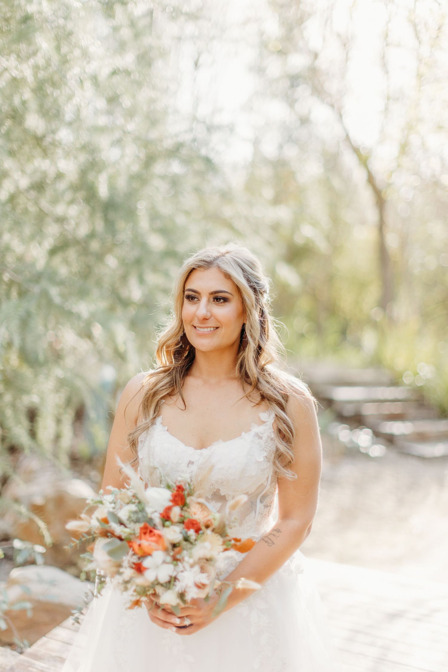 Wedding portrait showing a beautiful bridal bouquet with coral and white flowers against a soft natural backdrop.