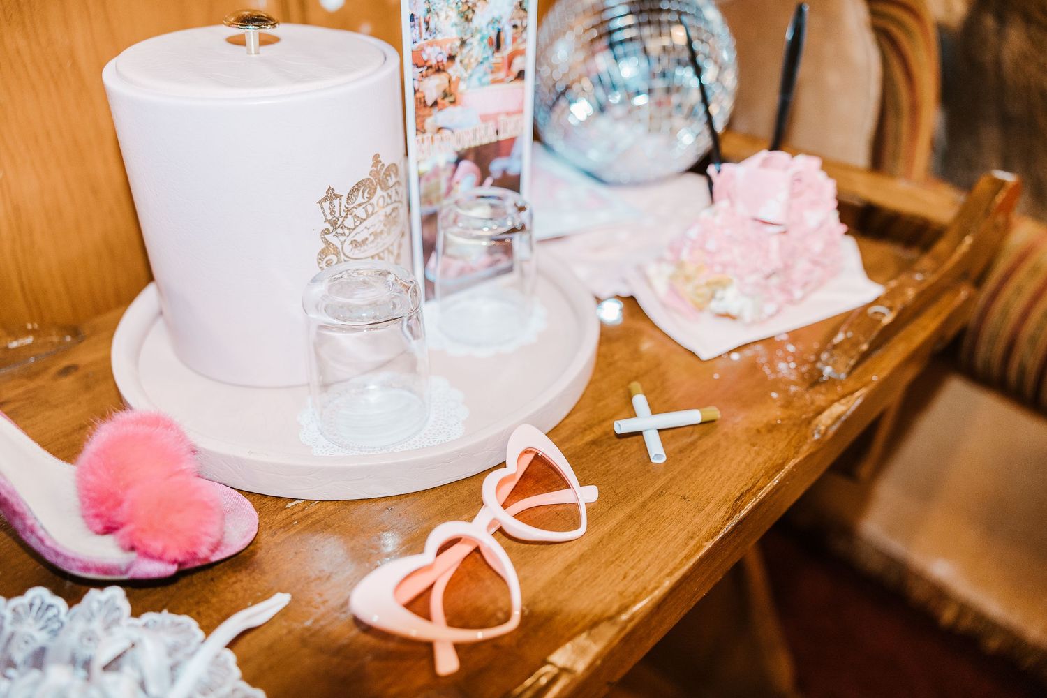 Pretty pink hair bows and decorative accessories arranged on a wooden table with a roll of white paper towels.