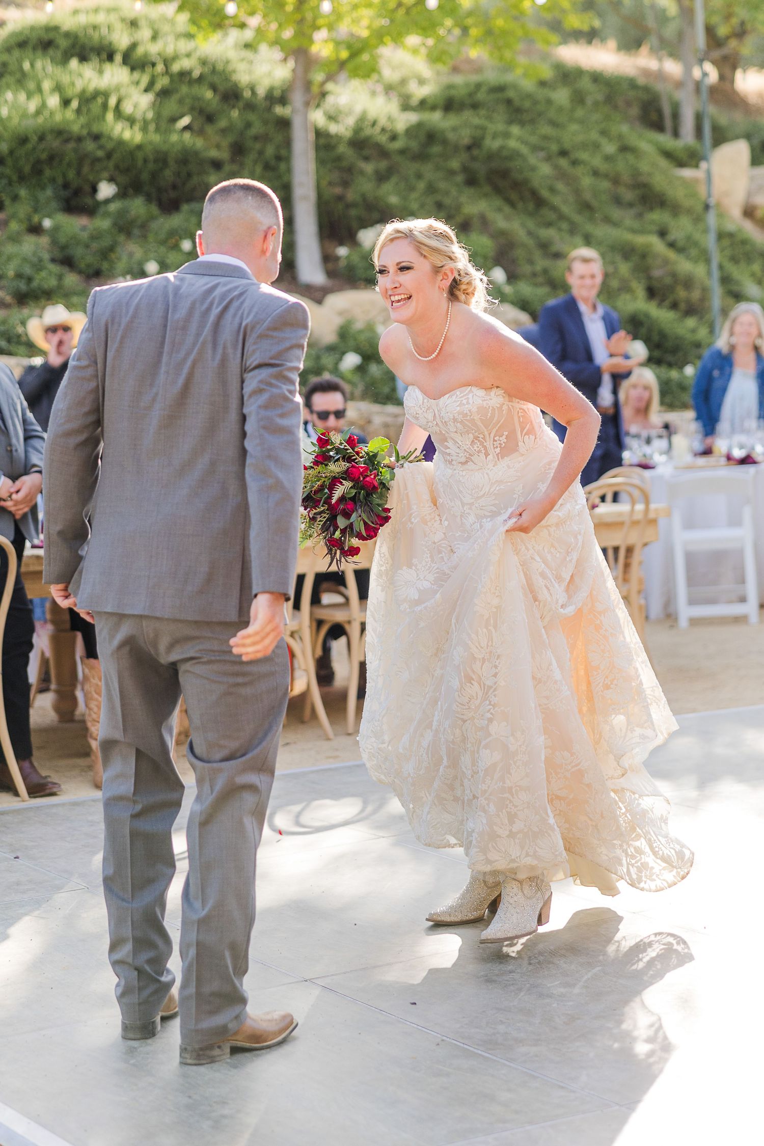 A couple sharing their first dance at an outdoor wedding reception.