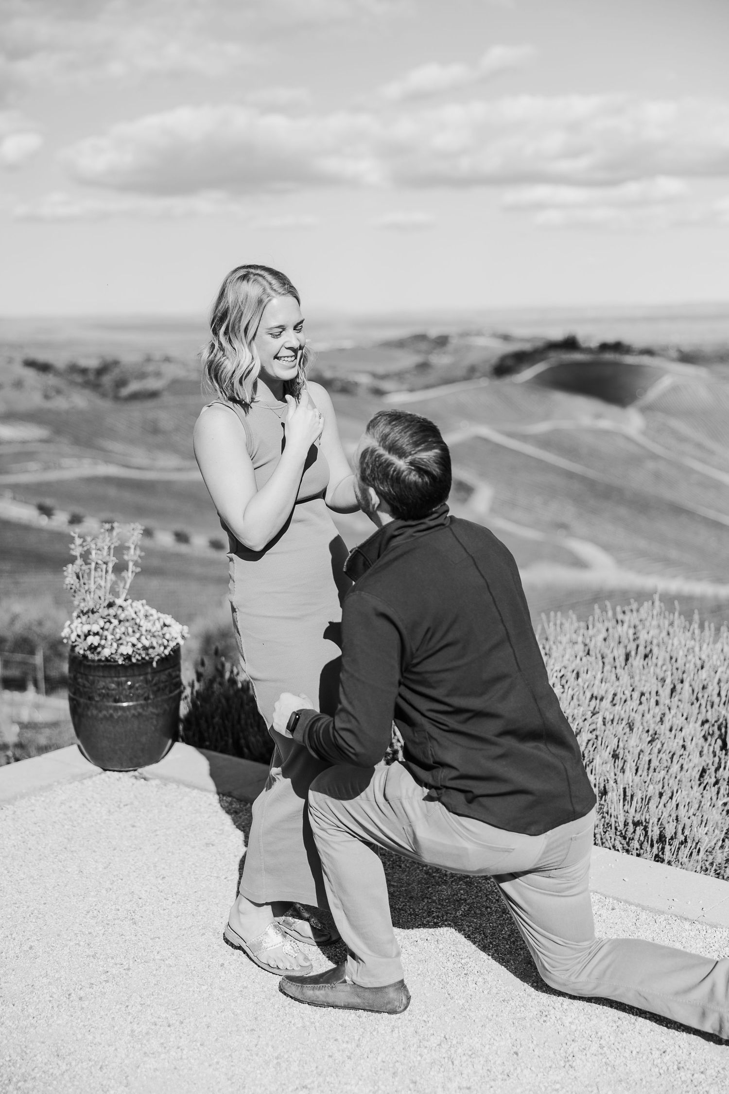 A black and white sequence of photos showing two people sitting together on a hilltop overlooking rolling landscapes.