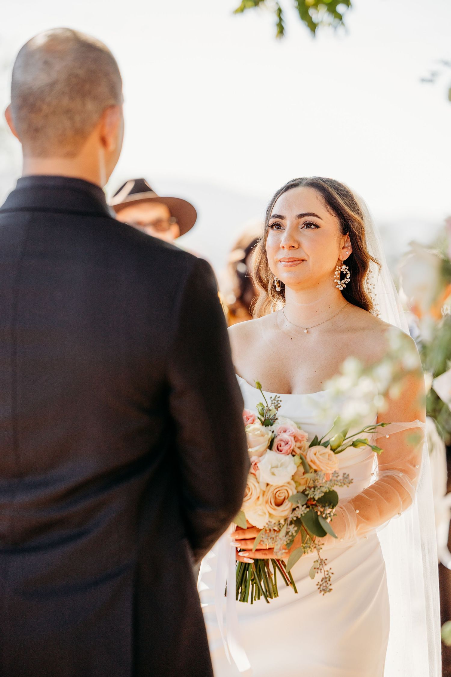 Bride and groom share first look moments in outdoor garden setting.