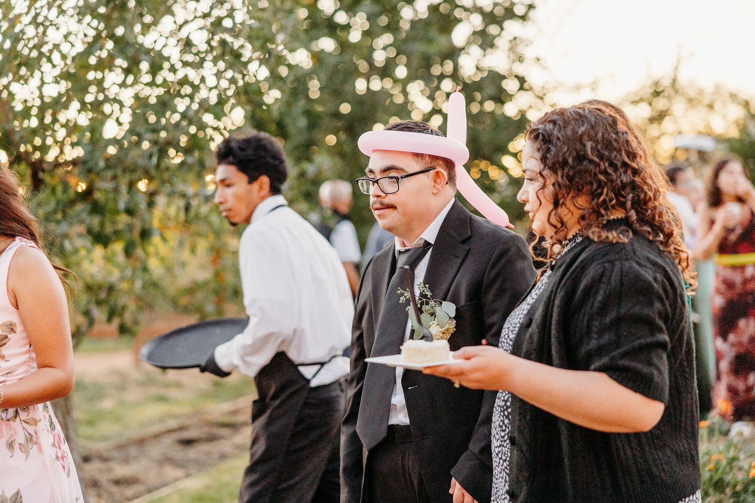 Wedding guests mingling and enjoying drinks at outdoor reception.
