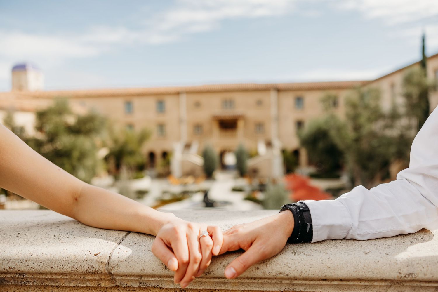 A romantic collage of hands touching and embracing in various poses against stone walls and outdoor settings.