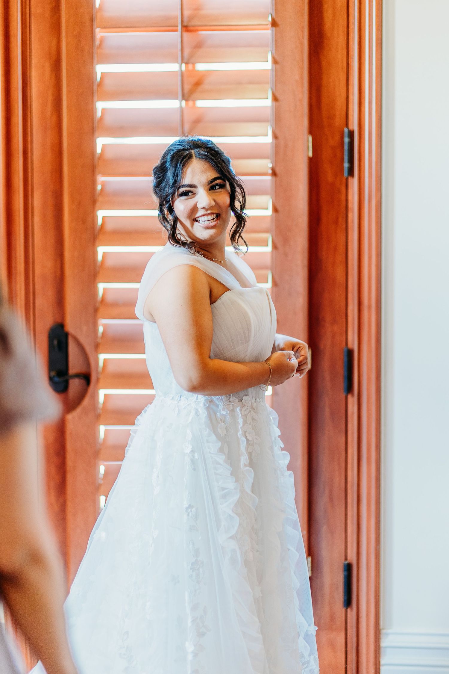 A beautiful bridal portrait featuring warm window light and wooden shutters creating a glowing atmosphere.