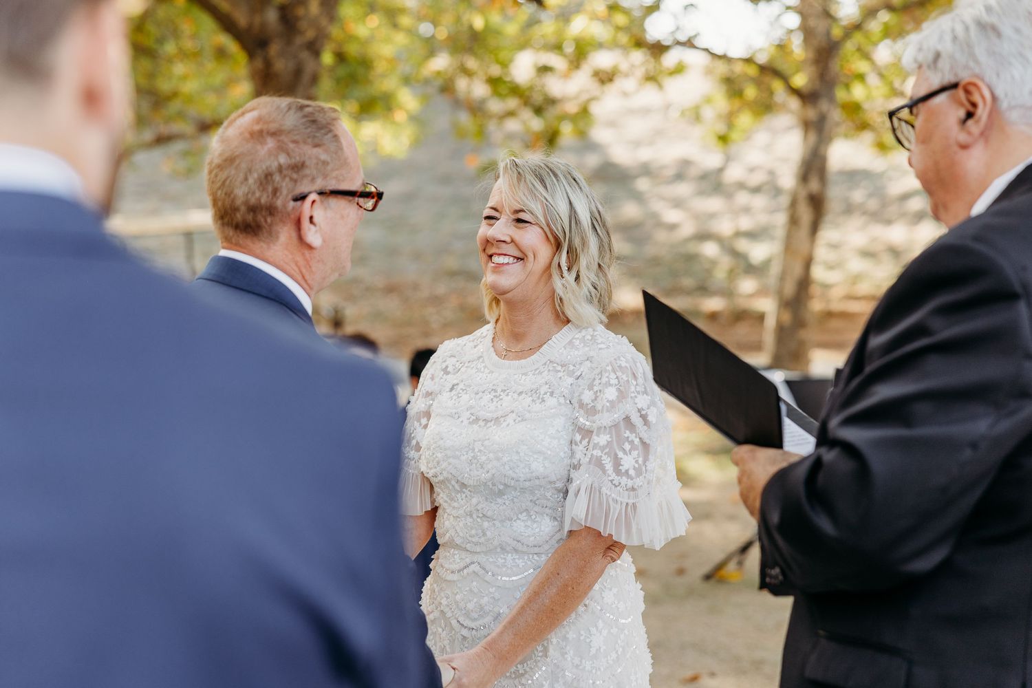 Black and white photo of a joyful outdoor celebration with formal attire.