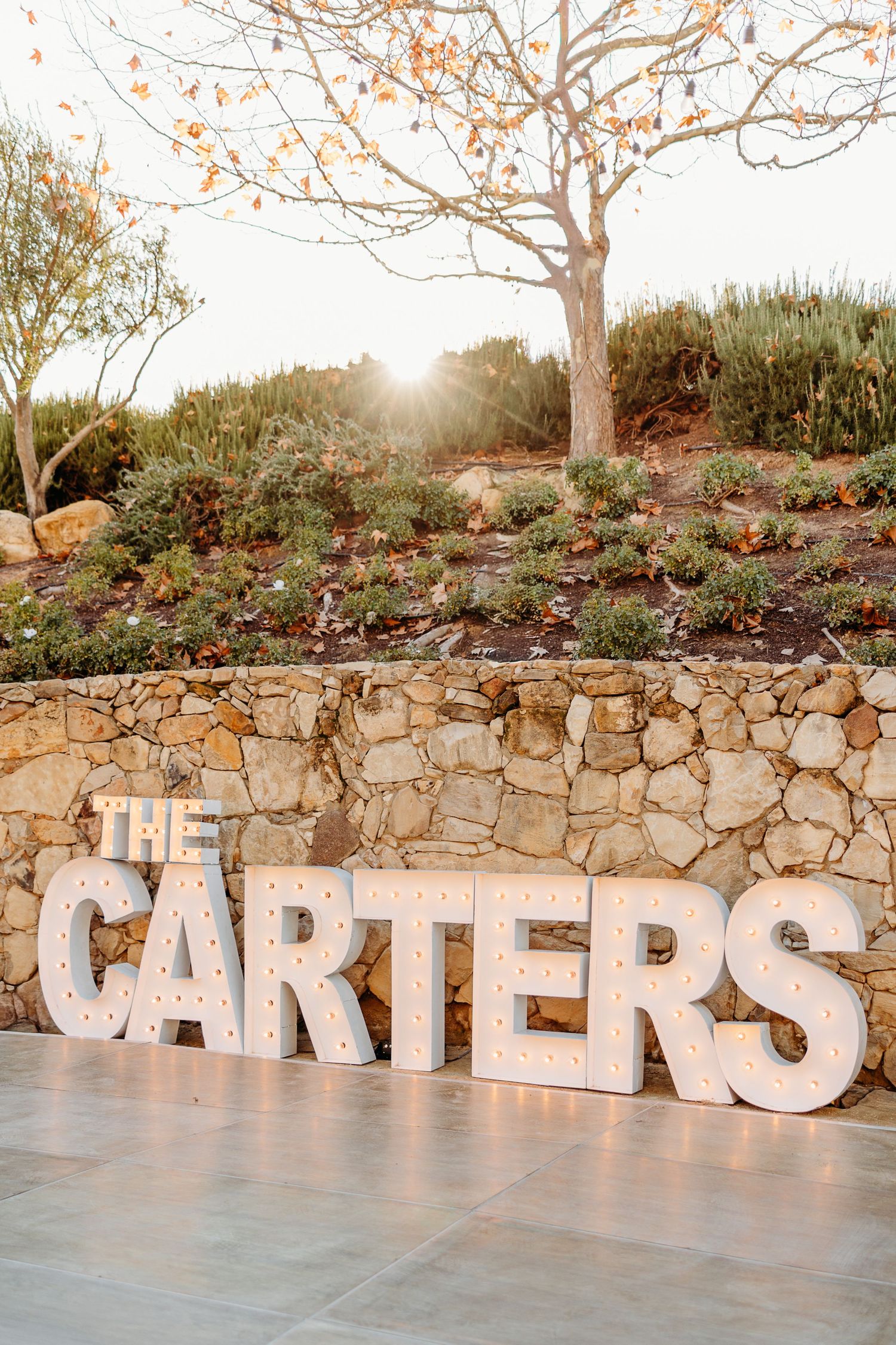 Large rustic letters spelling 'CARTERS' displayed against a stone wall at sunset.