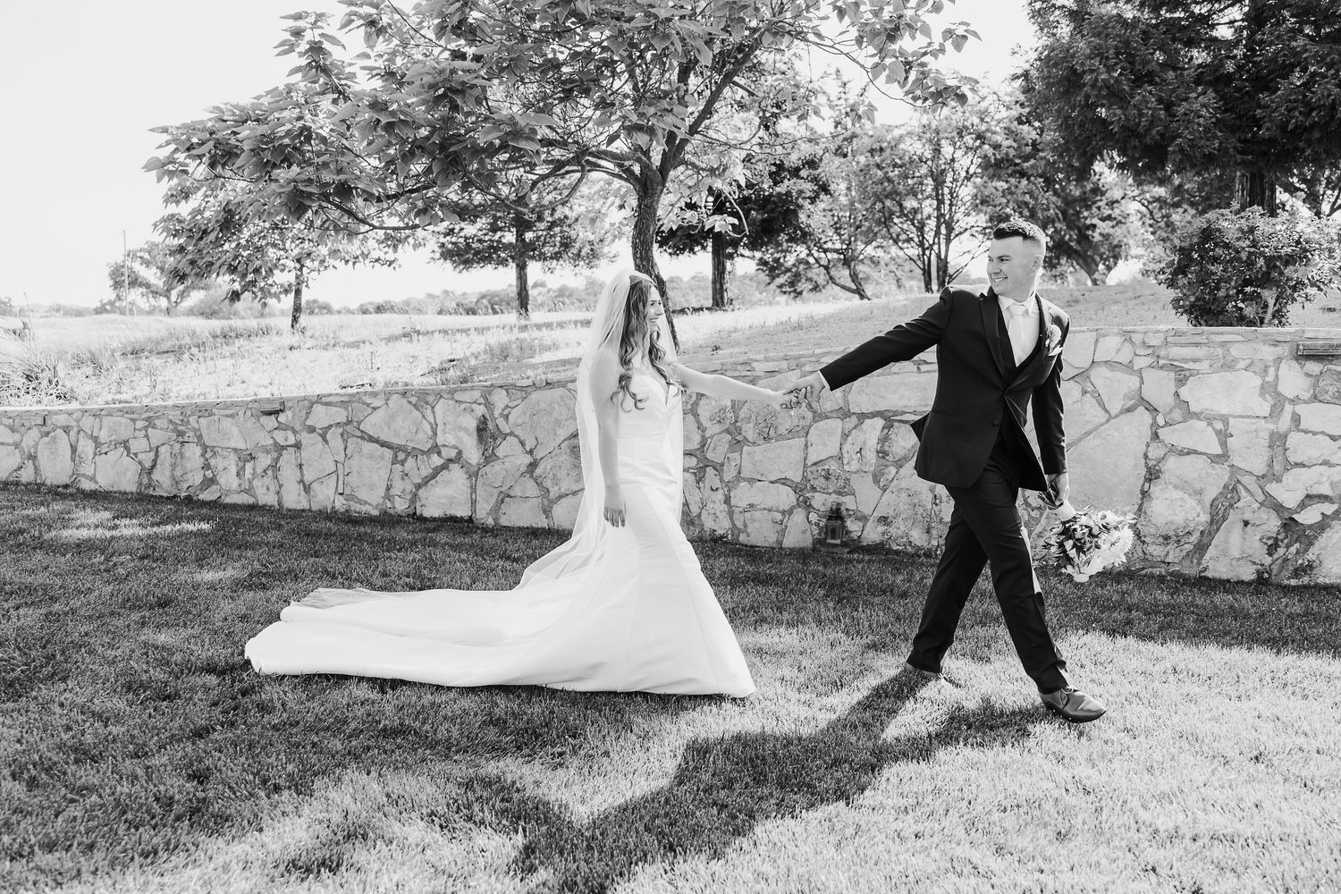 Romantic black and white wedding montage showing couple dancing and embracing in outdoor garden setting.