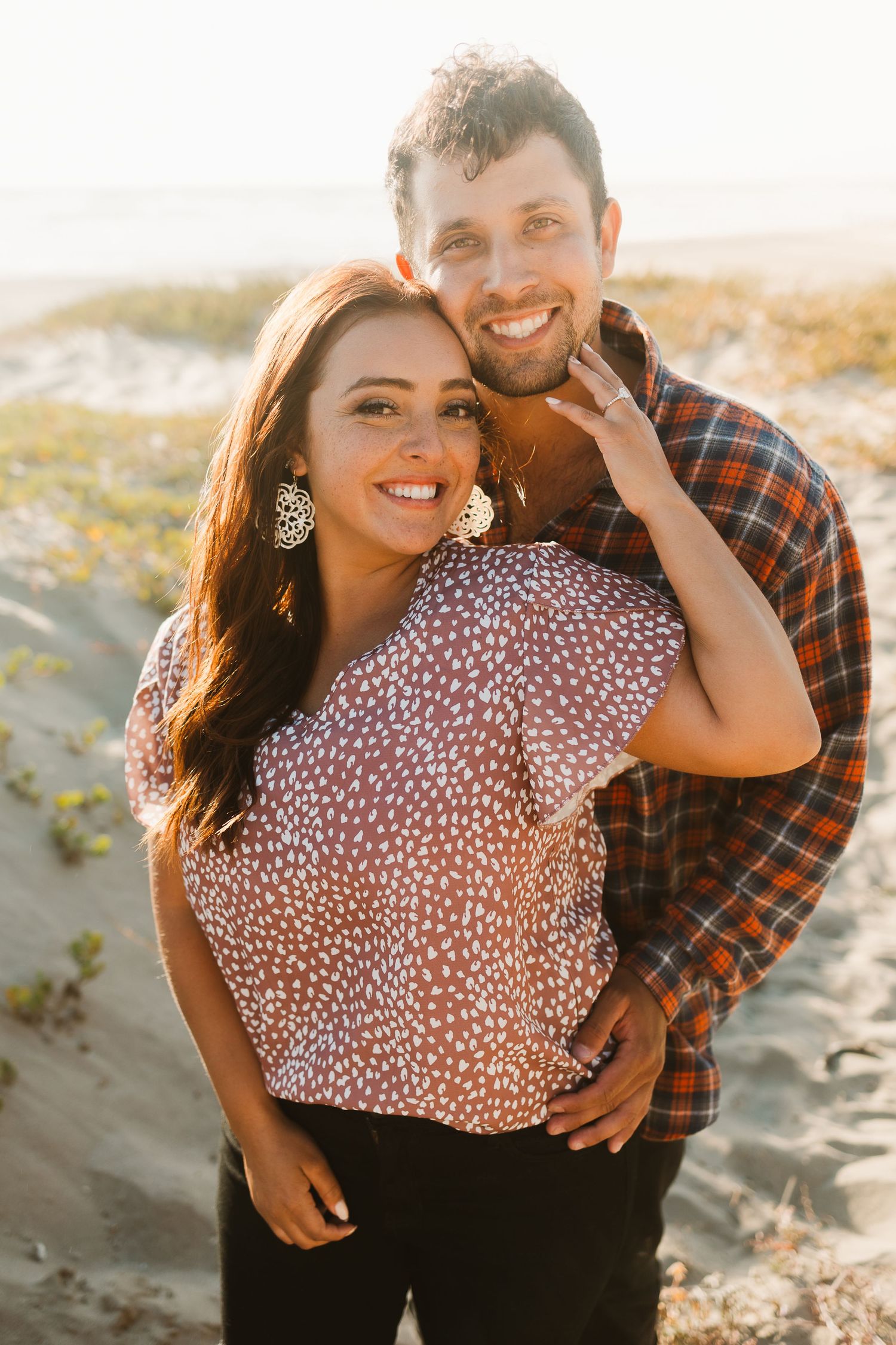 Happy couple in plaid and polka dots posing together outdoors.
