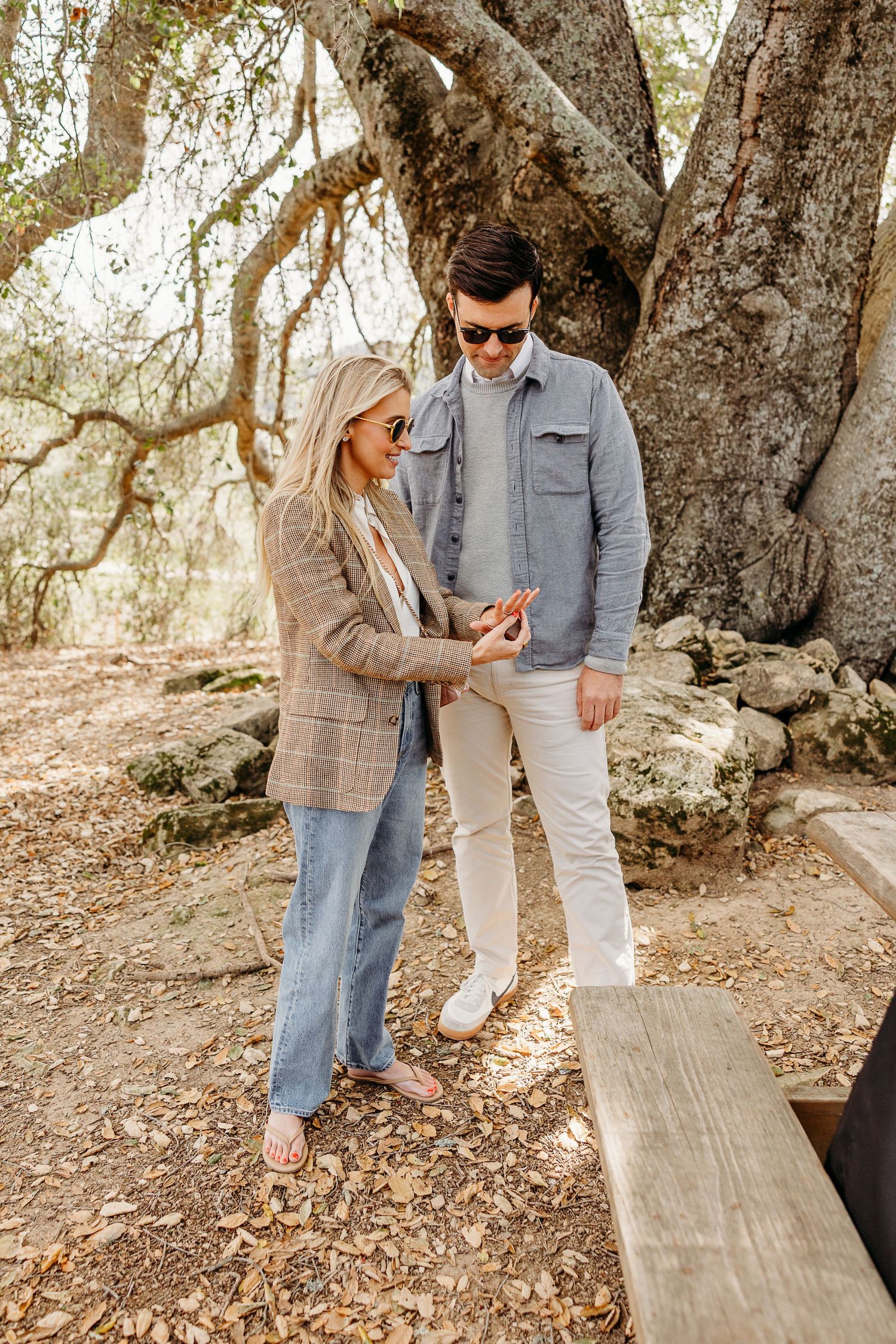 Romantic moment shared under twisted tree branches on a forest path.