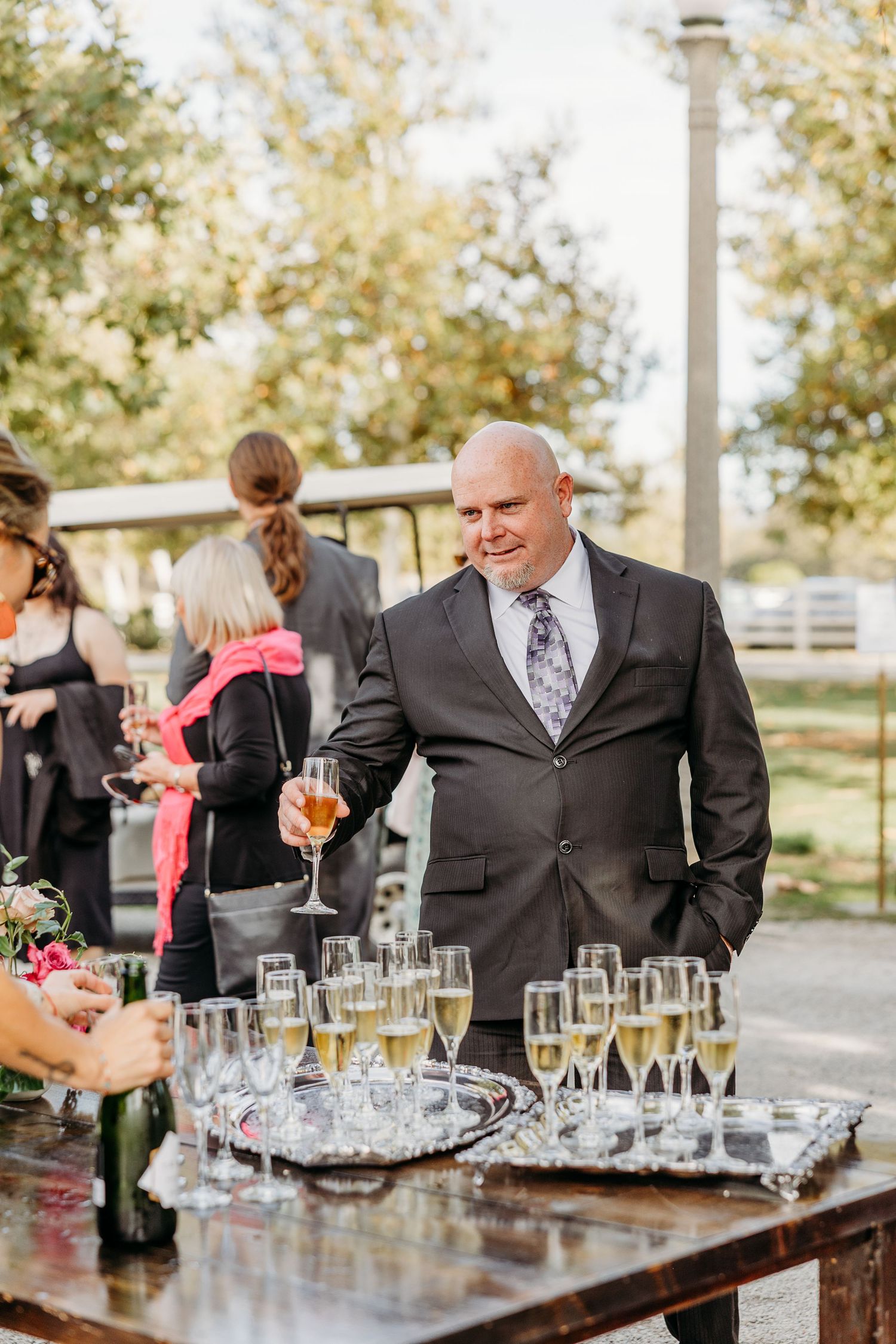 Elegant outdoor bar setup with champagne glasses and beverages at a wedding reception.