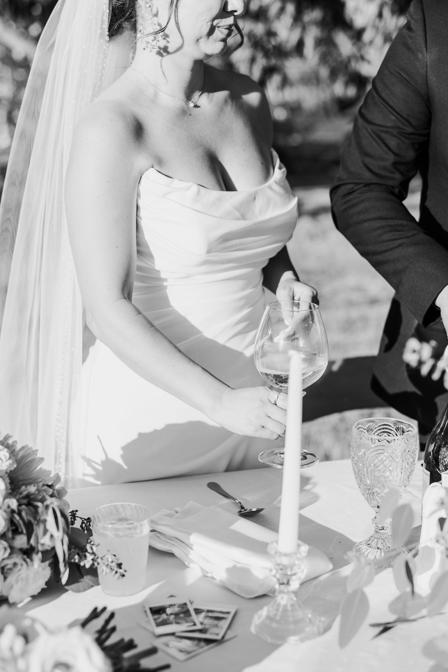 Elegant wedding table setting with white candles and floral decorations in black and white.